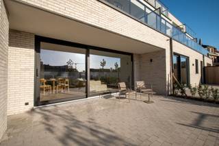 Volledig afgewerkt en instapklaar appartement met ruim terras en privatief tuintje.<br />Oplevering bij akte.<br /><br />Indeling: er is een inkomhal die toegang geeft tot twee slaapkamers, badkamer, toilet en keuken. Via de open keuken heb je overigens toegang tot een aparte berging, de lichtrijke leefruimte, ruim terras en tuin. De badkamer bestaat uit een inloopdouche en een dubbele lavabo.<br /><br />Volledig dubbellaags opgeschilderd, zowel muren als plafonds.<br />Mdf plinten en deuren geschilderd.<br /><br />De bewoonbare oppervlakte bedraagt 107,00 m². De oppervlakte van het terras bedraagt 29 m².<br /><br />Langs de doorgang naar achter bevinden zich de bergingen. Achteraan zijn de garageboxen met een oppervlakte van 18m², voorzien van manuele sectionale poort. Kan geautomatiseerd worden, voorzieningen voor het plaatsen van een laadpaal zijn ingewerkt.<br /><br />De prijs van de berging bedraagt 6.300,- euro. <br /><br />E-peil 30 (50% vrijstelling op onroerende voorheffing voor 5 jaar) in basis zijn 4 zonnepanelen (435 Wp/st) inbegrepen. Uitbreiding pv installatie is mogelijk zodat E-peil 10 gehaald wordt met volledige vrijstelling van onroerende voorheffing voor 5 jaar.<br /><br />Warmtepomp (lucht/water) met vloerverwarming met apart regelbare circuits per ruimte.<br /><br />Alle bedragen zijn exclusief garages, bergingen en alle kosten. Bijhorende berging nr. 6 dient mee aangekocht te worden. Er zijn nog 4 vrije garages, er kan één of meerdere mee aangekocht worden.<br /><br />Prijs voor het appartement met garage en berging is 395.948,- euro (exclusief registratie, btw, notaris en aansluitingskosten) Opsplitsing als volgt: grondaandeel 80.850,- euro, constructiewaarde 315.098,- euro.<br /><br />AANKOOP AAN 6% BTW OP CONSTRUCTIE MOGELIJK: zowel voor eigen bewoning als bij engagement tot lange verhuur (minstens 15 jaar)<br /><br />==> OPENDEUR ZATERDAG 24/10 VAN 9U-12U30<br />inschrijven kan via de website of via xavier@opt-immo of 0491 33 66 29