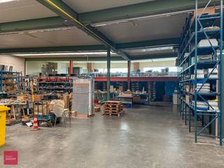 Ruime werkplaats / stapelruimte met grote sectionale poort, warmeluchtverwarming, verlichting, burelen, mezzanine, sanitair en grote oprit. Op...