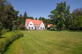 <p><span>Dit bijzondere eigendom is gelegen op een zeer rustige en groene locatie te Kapellen nabij Royal Antwerp Golf Club. Rust, een groene omgeving alsook een goede verbinding met het centrum van Heide-Kalmthout zijn troeven van deze locatie. Het domein van ruim 1 hectare groot omvat een recent gerenoveerde villa, een guesthouse, garage gebouw, zwembad en tennis terrein.</span></p><p><span> </span></p><p><span>Hoofdgebouw</span></p><p><span>U betreedt de villa middels de centrale inkomhal op parketvloer met trap naar de eerste verdieping alsook vestiaire, gastentoilet en toegang tot de kantoorruimte. De leefruimte werd opgedeeld in een zitkamer met open haard, aangename eetruimte en een tv-kamer. Deze drie ruimtes kunnen worden afgesloten middels schuifdeuren. Smaakvol ingerichte keuken met diverse inbouwtoestellen waaronder vaatwasser, koelkast, oven, gasvuur en dubbele spoelbak. Vanuit de keuken toegang tot de bijkeuken met kasten en toegang naar de kelderruimte. </span></p><p><span><br />1e Verdieping</span></p><p><span>Middels de trap bereikt u ruime nachthal met loungeruimte. De masterslaapkamer omvat een ruime dressing met ingemaakte kasten alsook een badkamer met bidet, toilet, douche, ligbad en dubbele lavabo. Tweede ruime slaapkamer met dressing en privatieve badkamer met ligbad, toilet en lavabo. Derde slaapkamer met lavabo, separate badkamer en een vierde slaapkamer met ingemaakte kasten. </span></p><p><span> </span></p><p><span>2e Verdieping / zolder</span></p><p><span>Toegang naar de zolderruimte middels vlieringtrap. De zolderruimte is opgedeeld in drie compartimenten. </span></p><p><span> </span></p><p><span>Kelder</span></p><p><span>De kelderruimte werd ingedeeld in verschillende ruimtes waaronder een wijnkelder, berging en een wasplaats met strijkgedeelte met aansluitingen voor wasmachine en droogkast.   Tevens is er een speelkamer of polyvalente ruimte en een relaxgedeelte of wellness met tevens toegang naar buiten toe (nota; deze ruimtes zijn nog niet gerenoveerd). Apart technisch lokaal met CV installaties (condenserende gasketels Buderus) alsook waterontharder. </span></p><p><span> </span></p><p><span>Guesthouse en polyvalent gebouw</span></p><p><span>Op het domein is een apart guesthouse in dezelfde stijl als het hoofdgebouw met 2 slaapkamers, 2 badkamers, een keuken en 2 garages. Een derde gebouw is polyvalent te gebruiken en bestaat uit een grote kantoorruimte en 2 extra garages.</span></p><p><span> </span></p><p><span>Bijzonderheden</span></p><p><span>Dit domein op ruim 1 hectare grond werd gerealiseerd in de jaren '50 en in 2022 werd de villa volledig gerenoveerd naar hedendaagse normen van luxe, comfort en afwerking. De villa heeft hiermee ook een EPC label B (172 KWH). </span></p><p><span>De tuin werd ook deels opnieuw aangelegd en hier treft u behalve een zwembad ook een tennis terrein. </span></p><p><span> </span></p><p><span>Meer inlichtingen via ons kantoor</span></p>