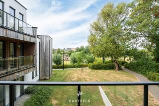 Een prachtig, lichtrijk hoekappartement geschikt voor jong en oud die rustig willen wonen met een heerlijk vrij zicht op het groen!<br /><br />Duurzaam, comfortabel en energiezuinig wonen in Kluisbergen. Dit nieuwbouwappartement van ca. 71 m² (incl. terras) bevindt zich op een gunstige hoek van het gebouw op het gelijkvloers. Hierdoor geniet u van extra lichtinval en een prachtig uitzicht over de grote, groene achtertuin met speeltuin. Het appartement is reeds volledig afgewerkt, enkel de schilderwerken moeten nog worden uitgevoerd.<br /><br />De troeven van dit appartement:<br />- Unieke hoekligging &amp; vrij zicht op het groen: Dankzij de ligging op de hoek van het gebouw geniet u van extra natuurlijke lichtinval.<br />- Energiezuinig &amp; toekomstbestendig: Dankzij de recentste isolatienormen en moderne bouwtechnieken geniet u van een uiterst lage energiefactuur en een aangenaam, constant binnenklimaat.<br />- Gelijkvloers met privatief terras &amp; gezellig tuintje: U geniet van het comfort van wonen op het gelijkvloers met een eigen onderhoudsvriendelijk terras en tuintje om in alle rust buiten te zitten.<br />- Volledig afgewerkt enkel schilderen volgens eigen smaak (incl. in de prijs): Het appartement is helemaal instapklaar op de schilderwerken na. Deze zijn reeds inbegrepen in de prijs, waardoor u het kleuren- en afwerkingspalet nog volledig naar eigen wens kunt kiezen.<br /><br />71 m² aan kwalitatieve &amp; optimaal comfort: De lichtrijke leefruimte is voorzien van een prachtige, tegelvloer en loopt naadloos over in de moderne, volledig geïnstalleerde open keuken. Daarnaast beschikt het appartement over één volwaardige slaapkamer, een ruime badkamer.<br /><br />Unieke gemeenschappelijke faciliteiten: Naast uw privatieve terras heeft u direct toegang tot de grote, mooi aangelegde gemeenschappelijke tuin met een petanquebaan, een ontmoetingszaal voor bewoners en een ruime veilige fietsenberging.<br /><br />Uitstekende ligging &amp; bereikbaarheid<br />Het appartement is prachtig gelegen in het hart van de Vlaamse Ardennen, op een boogscheut van het Kluisbos en bekende wandel- en fietsroutes zoals de Oude Kwaremont.<br /><br />Ondanks de rustige en groene omgeving is de bereikbaarheid uitstekend:<br />Verbindingen: Dankzij de nabijheid van de N60, N36 en N453 bereikt u vlot omliggende steden en gemeenten zoals Oudenaarde, Ronse, Avelgem, Maarkedal en Mont-de-l'Enclus. De snelweg E17 (oprit Waregem of Deerlijk) bevindt zich op slechts 15 tot 20 minuten rijden.<br /><br />Voorzieningen: Winkels voor de dagelijkse boodschappen (onder meer Delhaize, Spar en Carrefour Express), evenals lokale bakkers, slagers en apotheken bevinden zich in de directe nabijheid. Uitgebreider shoppen kan makkelijk in het nabijgelegen Oudenaarde of Ronse.<br /><br />Scholen: Verschillende basisscholen (zoals GBS De Start) en kinderopvangvoorzieningen liggen op wandel- of fietsafstand. Middelbare scholen in Ronse en Oudenaarde zijn eveneens vlot bereikbaar.<br /><br />Interesse in dit lichtrijke en energiezuinige hoek appartement? Neem contact op voor meer informatie of om een bezoek in te plannen!<br /><br />Stedenbouw in aanvraag.