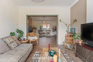 Voor meer info en foto’s, surf naar www.swevers.be – instapklare open bebouwing met 190 m² bewoonbare oppervlakte op een perceel van 5a12ca in de Kerkstraat 15 te Nieuwerkerken. De woning dateert van 1948, werd volledig gerenoveerd in 2012 en kreeg in 2021 een nieuwe keuken en een stijlvolle sfeerhaard. Dankzij de doordachte indeling, grote raampartijen en overvloedige lichtinval geniet u hier van een aangenaam wooncomfort. Op het gelijkvloers vindt u een ruime woonkamer, een gezellige eetkamer, een moderne keuken met veel werk- en bergruimte, een praktische berging en een gastentoilet. De eerste verdieping beschikt over twee ruime slaapkamers, waarvan één met ingebouwde kasten, een badkamer met aansluitende dressing, een apart toilet en een handige wasvoorziening. Via een vaste trap bereikt u de tweede verdieping, waar een hobby ruimte van 36 m² tal van mogelijkheden biedt als master bedroom. Daarnaast is er een kelder van circa 6 m². Buiten geniet u van een zonnige, zuidwestgerichte tuin met fruitbomen, een ruim terras en een overdekt terras. Vooraan is parkeergelegenheid voor drie wagens. Extra troeven zijn de airconditioning, tien zonnepanelen met groenestroomcertificaten en de energiezuinige voorzieningen. De ligging is eveneens een pluspunt, met openbaar vervoer op 100 meter, winkels, scholen en horeca op ongeveer 2 kilometer, een vlotte verbinding naar de snelweg en het Provinciaal Domein Nieuwenhoven op slechts 6 kilometer. Een ideale woning voor wie op zoek is naar ruimte, comfort en een rustige, centrale ligging. Voor meer informatie, bel 012 699 900. Bron bewoonbare oppervlakte: EPC – verslag.