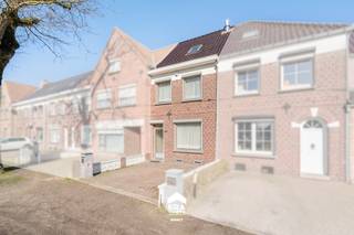 <p>[[ DIT PAND NEEMT DEEL AAN DE ERA OPEN HUIZEN DAG OP 14/3 VAN 9:30 TOT 10:30 ]]</p>

<p>Deze grotendeels gerenoveerde rijwoning ligt langs een invalsweg naar het centrum van Maaseik. Aan de voorzijde geniet je van een vlotte bereikbaarheid en zichtbaarheid, terwijl de achterzijde bereikbaar is via een rustige straat – bijzonder praktisch dankzij de doorgang naar de garage achteraan.</p>

<p>De woning werd gebouwd in 1957 en kreeg de voorbije jaren belangrijke vernieuwingen. Zo werd het dak vernieuwd, is er een aanbouw gerealiseerd die het woonvolume uitbreidt en werd de badkamer aangepakt. Binnenin beschik je over drie slaapkamers en een ruime zolderverdieping die nog verder kan worden ingericht naar eigen wens. De woning is goed onderhouden, onmiddellijk bewoonbaar en biedt een degelijke basis voor wie nog verder wil verfijnen.</p>

<p>Technisch zit het ook goed met zonnepanelen, een vernieuwde cv-ketel op stookolie, spouwisolatie aan de voorgevel en dubbele beglazing in het aluminium schrijnwerk.</p>

<p><strong>Enkele troeven</strong></p>

<ul><li>Vernieuwd dak en aanbouw – Extra woonruimte en structureel aangepakt.</li><li>3 slaapkamers + ruime zolder – Mogelijkheid om extra kamers of hobbyruimte te creëren.</li><li>Achterliggende doorgang met garage – Bereikbaar via rustige wijkstraat, bijzonder praktisch.</li><li>Degelijke technieken – Zonnepanelen, vernieuwde cv-ketel en dubbele beglazing.</li><li>Centrale ligging – Vlotte verbinding naar Maaseik centrum en voorzieningen.</li></ul>

<p>Op zoek naar een verzorgde woning met uitbreidingsmogelijkheden en een praktische ligging? Dan is dit zeker een bezoek waard!</p>