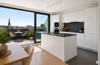 <p>Op zoek naar een zéér ruim en energiezuinig appartement met ondergrondse parking en kelderberging in hartje Beveren?<br /><br />Op de Grote Markt bevindt zich dit ruime duplexappartement uit 2020, met maar liefst 146,15 m² bewoonbare oppervlakte. Met drie slaapkamers, twee badkamers, twee terrassen van samen 19,97 m² en EPC-label A combineert het appartement een royale indeling met hedendaags wooncomfort en een centrale ligging.<br /><br />Het appartement strekt zich uit over de vierde en vijfde verdieping. Op de vierde verdieping komt u binnen via de ruime inkomhal, die toegang geeft tot de verschillende vertrekken. De royale leefruimte met open keuken vormt met haar oppervlakte van ruim 50 m² het hart van het appartement en biedt volop ruimte voor een comfortabele woon- en eetkamer.<br />De open keuken is praktisch en verzorgd ingericht en beschikt over een ziteiland met composieten werkblad, veel kastruimte en kwalitatieve toestellen van Miele. <br />Vanuit de leefruimte heeft u rechtstreeks toegang tot het zonnige terras van 13,35 m², een aangename uitbreiding van de woonruimte.<br /><br />Deze verdieping beschikt tevens over een eerste slaapkamer met ensuite badkamer en toegang tot het tweede terras. Daarnaast zijn er nog een praktische wasberging en een apart gastentoilet voorzien.<br /><br />Via de stijlvolle vaste trap bereikt u de vijfde verdieping. Hier bevinden zich een bureau, dat eveneens als tweede slaapkamer kan worden ingericht, en een derde slaapkamer. Deze laatste geeft toegang tot een zolder/dressing en biedt zo bijkomende praktische ruimte. De tweede badkamer is uitgerust met een douche, lavabo en toilet. Dankzij deze indeling beschikt het appartement over drie volwaardige slaap- of werkruimtes en twee badkamers, verdeeld over beide verdiepingen.<br /><br />Op technisch vlak is het appartement uitstekend uitgerust. Het is voorzien van aluminium ramen met superisolerende dubbele beglazing, centrale verwarming op aardgas, ventilatie type D, een conforme elektrische installatie en een videofoniesysteem. Het gebouw beschikt bovendien over een lift. Met EPC-label A is het appartement daarenboven bijzonder energiezuinig.<br /><br />Een eigen ondergrondse parkeerplaats en een afzonderlijke kelderberging van ca. 3 m² zijn inbegrepen.<br /><br />Kortom, een bijzonder ruim duplexappartement op de Grote Markt in Beveren, met 146,15 m² bewoonbare oppervlakte, drie slaapkamers, twee badkamers, twee terrassen, een energiezuinig EPC-label A en een eigen ondergrondse parkeerplaats met kelderberging.<br /><br />Benieuwd? Contacteer ons voor bijkomende informatie en/of een bezoek via verkoop@homevast.be of tel. 03 344 77 44 en kom dit appartement persoonlijk ontdekken.</p>