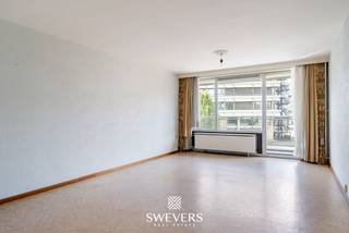 Voor meer info en foto’s, surf naar www.swevers.be – Aan Casterstraat 60 bus 4 in Hasselt bevindt zich dit op te frissen appartement met een bewoonbare oppervlakte van 92 m². Dankzij de centrale ligging woon je vlak bij het centrum, met winkels, openbaar vervoer, restaurants en scholen op wandelafstand. Het cultureel centrum ligt bovendien recht tegenover het gebouw. Het appartement dateert van 1977 en is bereikbaar met de lift. Het appartement beschikt over een gunstig EPC-label van B. De ruime woonkamer en eetkamer genieten dankzij grote raampartijen van veel natuurlijke lichtinval en geven toegang tot een breed terras aan de voorzijde. Aansluitend bevindt zich een afzonderlijke keuken. Aan de andere zijde liggen twee volwaardige slaapkamers, die beide toegang bieden tot een tweede terras. Verder beschikt het appartement over een badkamer en een apart toilet. De huidige staat biedt volop mogelijkheden om keuken, badkamer en afwerking volledig naar eigen smaak te vernieuwen. Extra praktisch zijn de beveiligde inkomdeur, een kelderberging van 3 m² en parkeermogelijkheid voor de deur. Met twee slaapkamers, twee terrassen en een ruime, lichtrijke leefzone vormt dit appartement een interessante basis voor wie op zoek is naar ruimte én renovatiemogelijkheden op een centrale locatie in Hasselt. Voor meer informatie, bel 011 255 155. Bron bewoonbare oppervlakte: EPC – verslag.
