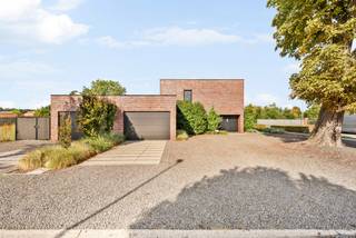 Bent u op zoek naar een uitzonderlijke eigendom waar comfortabel wonen en professioneel ondernemen perfect samengaan? Dan is deze ruime villa een unieke opportuniteit.<br /><br />Deze woning beschikt over een aparte zijingang, een wachtzaal, toilet en twee praktijk- of kantoorruimtes, waardoor cliënten of patiënten volledig gescheiden van het privé-gedeelte kunnen worden ontvangen. Het pand is uitermate geschikt voor vrije beroepen, een groepspraktijk, advocaten- of accountantskantoor, consultancy of andere professionele activiteiten.<br /><br />Dankzij de royale indeling en de afzonderlijke toegang biedt deze eigendom bovendien uitstekende mogelijkheden voor kangoeroewonen of een zorgwoning (onder voorbehoud van de geldende stedenbouwkundige voorschriften). Zo kunnen meerdere generaties comfortabel samenwonen met behoud van ieders privacy.<br /><br />De woning zelf biedt alle ruimte voor een groot gezin en beschikt over drie volwaardige slaapkamers, dressing, badkamer en een praktische wasplaats.<br /><br />Een extra troef is de volledig onderkelderde verdieping, voorzien van leidingen verwarming en voorzieningen om eventueel om te vormen als leef- of hobbyruimte. Daarnaast beschikt de woning over een dubbele garage.<br /><br />Buiten wordt u verwelkomd in een prachtig aangelegde tuin waar rust en privacy centraal staan. Dankzij de volwassen beplanting en de doordachte inrichting geniet u hier het hele jaar door van een groene oase. Ook aan parkeergelegenheid is gedacht, met voldoende parkeerplaatsen op eigen terrein voor bewoners, cliënten en bezoekers.<br /><br />Buitengewone kenmerken;<br />- Woning met professionele mogelijkheden<br />- Instapklaar, modern<br />- Zonnepanelen<br />- Airco <br />- Rolluiken/Screens<br />- Geschikt voor kangoeroewonen of zorgwonen (onder voorbehoud van vergunning).<br />- Onderkelderd.<br />- Dubbele garage.<br />- Voldoende parkeerplaatsen op eigen terrein.<br /><br /><br />Deze veelzijdige villa combineert ruimte, comfort en functionaliteit op een uitzonderlijke manier. Of u nu op zoek bent naar een exclusieve gezinswoning, een praktijk aan huis, een eigendom voor meerdere generaties of een combinatie van wonen en ondernemen, deze unieke eigendom biedt tal van mogelijkheden en is klaar voor een nieuw hoofdstuk.
