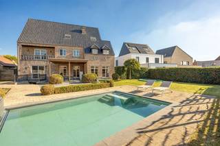 <p><span>Op zoek naar een royale gezinswoning met karakter, een zalige tuin én uitzonderlijk veel ruimte? Deze prachtige villa in pastorijstijl heeft het allemaal: een gezellige leefruimte, 4 slaapkamers, een aparte woonverdieping, een volledig ingerichte kelder en een zonnige tuin met zwembad. De rustige ligging in Oosthoven krijg je er zo bij!</span></p><p><span> </span></p><p><span>In een rustige straat in Oosthoven, achter een charmante gevel in baksteen, vind je deze mooie villa uit 2006. De grote oprit biedt plaats aan minstens drie wagens, en daarnaast heb je nog een dubbele garage. Binnen wacht je maar liefst ca 434 m² bewoonbare oppervlakte, met een warme, landelijke afwerking en heel wat mooie details.</span></p><p><span> </span></p><p><span>Licht, ruimte en charme</span></p><p><span>Via de inkomhal met z'n landelijke tegelvloer stap je binnen. Je vindt hier een handige ingemaakte vestiairekast, een apart gastentoilet en toegang tot een extra kamer die momenteel als speelkamer wordt gebruikt, maar evengoed dienst kan doen als thuisbureau.</span></p><p><span>Door de dubbele deuren kom je in de royale leefruimte, waar het daglicht langs de vele ramen binnenvalt en je een mooi zicht hebt op de tuin. Het salon heeft een warme parketvloer en een gezellige houthaard, perfect voor lange winteravonden. De sierlijsten en plafondrozet geven het geheel nog wat extra karakter.</span></p><p><span>Aansluitend heb je de eetruimte en de landelijke keuken, allebei op een rustieke tegelvloer. De keuken is ingericht met witte kastfronten, een donker werkblad, een elektrische kookplaat met oven, dampkap, spoelbak, vaatwasser en heel wat kastruimte. Er is ook meer dan genoeg plaats voor een grote eettafel. Dankzij de grote schuiframen geniet je hier van veel licht en stap je zo naar buiten.</span></p><p><span>En wat voor een buitenplek! De zuidwestgerichte tuin is mooi aangelegd, met een groot gazon, verzorgde hagen, een zwembad en een heerlijk terras met overkapping. Ideaal voor een frisse duik op warme dagen, een gezellige barbecue of een rustig koffietje in de schaduw. Aan beide kanten van de woning heb je een poortje naar de tuin.</span></p><p><span> </span></p><p><span>Vier grote slaapkamers en een luxe badkamer </span></p><p><span>Op de eerste verdieping vind je vier ruime slaapkamers, met heel wat ingemaakte kasten. Eén kamer heeft toegang tot een balkon, een andere valt meteen op door het prachtige ronde raam en de indrukwekkende plafondhoogte. Ook hier zie je de landelijke stijl terugkomen, gecombineerd met warme houten vloeren en veel natuurlijk licht.</span></p><p><span>De grote badkamer heeft bijna de allures van een wellness, met haar vrijstaande bad op sierlijke pootjes, ruime douchecabine, dubbele lavabo op een houten meubel en toilet. De zuilen, sierlijsten en lichte natuursteenkleuren maken het plaatje compleet.</span></p><p><span> </span></p><p><span>Een extra woonverdieping én een kelder vol mogelijkheden</span></p><p><span>De tweede verdieping is ingericht als een volwaardige extra woongedeelte, met een gezellige zithoek, open keuken, aparte slaapkamer en eigen badkamer. De schuine plafonds en dakramen zorgen voor een warme, huiselijke sfeer. Een heerlijke plek voor een inwonende student, een ouder kind dat wat zelfstandigheid wil of gasten die graag hun eigen stekje hebben. Ook voor kangoeroe wonen of Airbnb zijn hier mogelijkheden. Bovendien vinden we hierboven nog een zolder die bereikbaar is via een vlizotrap voor extra opbergruimte.</span></p><p><span>En dan is er nog de volledig ingerichte kelder, die je zowel vanuit de woning als via een brede buitentrap in de tuin bereikt. Hier heb je een grote polyvalente ruimte, momenteel ingericht voor ontspanning en fitness, met een eigen toilet. Een thuisbioscoop, hobbyruimte, speelparadijs of je eigen café? Aan plaats geen gebrek! Daarnaast vind je er nog een berging en technische ruimte.</span></p><p><span> </span></p><p><span>Rustig wonen in het groene Oosthoven</span></p><p><span>Je woont hier in Oosthoven, een fijne, residentiële omgeving in Oud-Turnhout, waar rust en bereikbaarheid mooi samengaan. Achter de tuinen ligt een groot speelplein, ideaal voor kinderen, en ook scholen zoals basisschool Reuzepas zijn in de buurt. Voor winkels, horeca en een terrasje op de Grote Markt fiets je makkelijk naar het centrum van Turnhout. Dankzij de goede verbindingen bereik je ook Antwerpen en de Nederlandse grenssteden vlot.</span></p><p><span> </span></p>