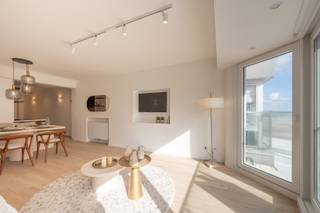 <strong>Smaakvol gerenoveerde appartement met zijdelings zeezicht</strong><br /><br />Indeling: Bij het binnenkomen word je verwelkomd in een inkomhal met een gastentoilet. De lichtrijke leefruimte sluit naadloos aan op het zonnige voorterras en biedt een mooi zicht op zee en het Lichttorenplein. De open keuken is volledig uitgerust en stijlvol afgewerkt.<br />Het appartement beschikt over twee volwaardige slaapkamers met ingemaakte kasten. Eén van de kamers biedt toegang tot een terras aan de achterkant. De moderne badkamer is voorzien van een ruime inloopdouche.<br /><br />Contacteer ons voor een bezoek!<br /><br />EPC: 66 kWh/m²/jaar - UC: 2869520-RES-1