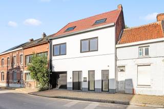 Deze ruime woning met een gunstige EPC-score van 117 kWh/m²/jaar (label B) bevindt zich op een rustige locatie, op wandelafstand van een school en de idyllische oevers van de Schelde. De moderne uitstraling springt meteen in het oog dankzij de combinatie van zwarte aluminium en pvc-ramen met een strakke witte gevelafwerking en een stijlvolle arduinen plint.<br /><br />Binnenin wordt u verwelkomd door een eigentijds interieur met hoogwaardige afwerking: grote rechthoekige vloertegels, hoge plafonds, elegante opdekdeuren en meerdere stalen binnendeuren met glas zorgen voor een open en lichtrijke sfeer. Extra comfort wordt geboden door onder andere een videofoon en subtiele designverlichting.<br />De woning werd grondig vernieuwd en is uitgerust met duurzame technieken zoals een warmtepomp (Viessmann Vitocal 111), ventilatiesysteem type D, 18 cm dakisolatie en 10 cm gevelisolatie.<br />De royale leefruimte baadt in natuurlijk licht dankzij een Velux-koepel met driedubbele beglazing. Via het brede schuifraam heeft u toegang tot het terras en de volledig omheinde tuin met groen uitzicht – een ideale plek om tot rust te komen.<br />De open keuken is een echte blikvanger, met een strak wit composiet werkblad en een centraal eiland. De combinatie van zwarte en witte kastelementen geeft het geheel een moderne toets. De keuken is volledig uitgerust met kwaliteitsvolle toestellen, waaronder een design dampkap, gasfornuis, oven, koelkast, vaatwasser en microgolf.<br />Praktisch comfort vindt u in de extra bergruimte: een kelder, een handige berging onder de metalen trap met houten treden en een aparte wasplaats aansluitend aan de garage.<br />Op de eerste verdieping bevindt zich een ruime badkamer die toegang biedt tot een bijzonder grote master bedroom met parketvloer en hoog plafond, evenals een tweede slaapkamer van meer dan zes meter lang. De badkamer is voorzien van een inloopdouche, dubbel lavabomeubel, hangtoilet en een stijlvolle zwarte radiator.<br />De tweede verdieping herbergt een derde, ruime slaapkamer met een eigen en-suite badkamer, uitgerust met een lavabomeubel, inloopdouche met glazen wand, hangtoilet en sierradiator. Daarnaast is er ook een technische berging aanwezig.