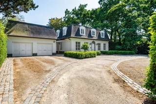 <p>Villa with French charm on a spacious 12,482 m² estate</p><p>After parking in the parking lot, which accommodates 7 cars, we enter the home through the imposing entry hall, finished entirely in white marble. From this central space, you have access to the living room, the office, the kitchen, the laundry room, and the guest restroom. The living area offers the option to separate the living room from the dining area, providing optimal flexibility when entertaining guests.<br />Adjacent to this is the spacious, fully equipped kitchen with all modern conveniences. Both the living room and the kitchen provide direct access to the veranda, a cozy spot with a fireplace and stunning views that you can enjoy year-round.<br />The first floor features four bedrooms, three bathrooms, a walk-in closet, and two separate restrooms.<br />The annex includes two indoor garages, equipped with two charging stations for electric cars, along with a relaxation area that can easily be converted into a professional workspace if desired. Solar panels have been installed on the roof of the annex.<br />The greatest asset of this property lies at the rear: a sprawling park-like garden with a large natural pond, a valuable biotope that creates a unique landscape—the view from the home is captivating all year round.<br />Schedule a visit and let yourself be surprised by this exceptional home.</p>