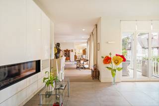 Appartement de villa exceptionnel d'environ 330 m²! Une combinaison rare de l'espace et de la grandeur d'une villa spacieuse avec le confort, l'intimité et la facilité d'entretien d'une résidence. L'architecture imposante, les jardins magnifiquement aménagés et la finition de haute qualité soulignent le caractère exclusif de l'ensemble. Avec sa superficie habitable exceptionnelle, ses espaces extérieurs généreux et sa disposition très réfléchie, cet appartement est le haut de gamme absolu de Schilde.<br /><br />Disposition:<br />Le hall d'entrée privatif avec vestiaire et toilettes forme immédiatement une introduction élégante et donne accès aux espaces de vie par des portes intérieures en acier élégantes.<br /><br />Au centre se trouve le salon exceptionnellement spacieux d'environ 90 m², divisé en différentes zones de vie harmonieusement connectées avec une salle à manger formelle, un salon spacieux autour de la cheminée à gaz et des coins salon et lecture supplémentaires. Des meubles sur mesure de haute qualité, des parquets chaleureux et de nombreuses fenêtres créent une atmosphère intemporelle et raffinée.<br /><br />La cuisine spacieuse d'environ 38 m² forme une deuxième pièce de vie complète et a été équipée d'un grand îlot central, de plans de travail en pierre naturelle, de meubles sur mesure et d'appareils Miele de haute qualité. La salle à manger intégrée, également avec cheminée à gaz, donne directement sur la terrasse en grande partie couverte d'environ 26,9 m². Un débarras / buanderie pratique complète cette zone.<br /><br />La suite principale forme une aile particulièrement privée avec une chambre spacieuse d'environ 37 m², un dressing entièrement aménagé d'environ 18 m² et une luxueuse salle de bains avec double vasque, douche à l'italienne et baignoire jacuzzi. La chambre donne un accès direct aux espaces extérieurs à l'arrière.<br /><br />Une deuxième chambre spacieuse dispose de meubles sur mesure, d'un balcon privé et d'une salle de bains séparée avec douche à l'italienne. Le bureau séparé d'environ 25,5 m² attenant au salon, grâce à ses dimensions généreuses, peut être parfaitement aménagé à nouveau en 3ème chambre.<br /><br />L'appartement dispose de cinq terrasses et balcons répartis sur différents côtés, totalisant environ 62 m² d'espace extérieur. À l'avant, on profite d'une salle extérieure spacieuse et abritée attenante à la cuisine, tandis que les terrasses à l'arrière offrent une vue sur la verdure mature du domaine.<br /><br />Détails:<br />- Environ 330 m² de surface habitable<br />- Salon exceptionnellement spacieux d'environ 90 m²<br />- Cuisine d'environ 38 m² avec électroménagers Miele<br />- 2 chambres + bureau / possibilité de 3 chambres<br />- 2 salles de bains<br />- Suite principale avec dressing spacieux<br />- Environ 62 m² de terrasses et balcons<br />- Garage fermé pour 2 grandes voitures avec espace de rangement supplémentaire<br />- Cave privative séparée<br />- Meubles sur mesure de haute qualité et finition intemporelle<br />- Étiquette énergétique A