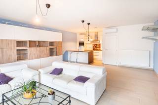 <p>In een verzorgd gebouw van 2018 vind je dit modern en energiezuinig appartement op de tweede verdieping, vlot bereikbaar met lift en trap. De leefruimte is ruim en lichtrijk dankzij de grote raampartijen en geeft rechtstreeks toegang tot het overdekte terras – een aangename plek om in alle rust van de buitenlucht te genieten.</p>
<p>De open keuken sluit mooi aan op de leefruimte en is volledig uitgerust met hedendaagse toestellen. Aansluitend bevindt zich een praktische berging met aansluiting voor wasmachine en droogkast. Aan de achterzijde van het appartement zijn er twee volwaardige slaapkamers en een stijlvolle badkamer met dubbele lavabo en inloopdouche.</p>
<p>Het appartement is volledig instapklaar en voorzien van airconditioning, een conforme elektrische keuring en een uitstekende energieprestatie (EPC A).</p>
<p>Ondergronds zijn er twee autostaanplaatsen beschikbaar, aan te kopen mits een meerprijs van € 25.000 per staanplaats.</p>
<p>De ligging is bijzonder aangenaam: op wandelafstand van winkels, scholen en openbaar vervoer. Dankzij de nabijgelegen invalswegen bereik je vlot Mechelen, de E19 en de omliggende gemeenten.</p>
<p>Een comfortabel, recent en energiezuinig appartement voor wie zorgeloos wil wonen op een centrale en goed bereikbare locatie.</p>
<p> </p>