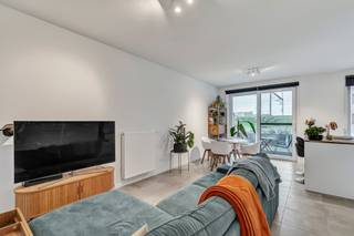 <p>U betreedt het appartement via de inkomhal met vestiaire en gastentoilet. </p><p>De lichtrijke leefruimte met open keuken geeft uit op het terras en de fraai aangelegde binnentuin. </p><p>De moderne keuken is uitgerust met een kookplaat, dampkap, oven en vaatwasmachine. </p><p>Het keukeneiland biedt bovendien extra zitruimte en creëert een gezellige verbinding met de leefruimte.</p><p></p><p>Aansluitend bevindt zich een praktische berging met aansluiting voor wasmachine en droogkast. </p><p>De hedendaagse badkamer beschikt over een inloopdouche en een dubbel lavabomeubel. </p><p>Verder telt het appartement twee volwaardige en lichtrijke slaapkamers.</p><p></p><p>In de ondergrondse garage is een autostaanplaats aanwezig, voorzien van elektriciteit. </p><p>Daarnaast beschikt het gebouw over een gemeenschappelijke afvalruimte en fietsenberging. </p><p>Er bestaat eveneens de mogelijkheid om een ruime garage aan te kopen, ideaal voor het stallen van een voertuig en/of extra opslagruimte.</p><p></p><p>Het appartement geniet van een uitstekende ligging op wandelafstand van het centrum, het station, scholen, winkels en de fietssnelweg F8 tussen Kortrijk en Gent.</p><p></p>