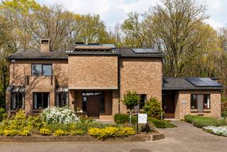 Voor meer info en foto’s, surf naar www.swevers.be – Deze ruime open bebouwing aan de Koerselsesteenweg 146 in Beringen combineert comfortabel wonen met professionele mogelijkheden. Dankzij aparte ingangen voor het privé- en praktijkgedeelte is de woning ideaal voor een zelfstandige activiteit aan huis, maar ook geschikt voor kangoeroewonen. De woning dateert van 1980 en werd doorheen de jaren gericht vernieuwd, met onder meer een nieuw pannendak, gerenoveerde living en keuken, vernieuwde condensatieketel, drie nieuwe Veluxramen en zonnepanelen uit 2023. Met een bewoonbare oppervlakte van 340 m² is er bijzonder veel ruimte. Op het gelijkvloers bevinden zich een woonkamer met eetkamer van samen 46 m², een keuken van 16,40 m², bureau en apart toilet. Het praktijkgedeelte omvat een wachtruimte, consultatieruimte, archief/doka en eigen toilet. Daarnaast zijn er een inpandige garage van 42 m² en een ruime berging. De eerste verdieping telt vier slaapkamers van 12,5 tot 22 m², waarvan één met terras en één met ingemaakte kasten. Verder zijn er een badkamer en apart toilet. De kelder van 44 m² zorgt voor extra bergruimte. Het perceel van 37a 75ca beschikt over een groen aangelegde tuin met meerdere terrassen en tuinhuisjes. Er is parkeerruimte voor 8 à 10 wagens. Scholen, openbaar vervoer en de snelweg zijn vlot bereikbaar. Extra troeven zijn het alarmsysteem, rolluiken, zonnewering en een beveiligde deur. Voor meer informatie, bel 011 255 155. Bron bewoonbare oppervlakte: EPC – verslag.
