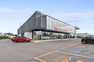 Bent u op zoek naar een nieuw, ruim en multifunctioneel bedrijfspand? Deze indrukwekkende faciliteit biedt een ideale combinatie van een ruime showroom, volledig uitgeruste kantoren en een groot magazijn, perfect voor diverse bedrijfsactiviteiten. Het prachtige gebouw daterend uit 2020 beschikt over grote raampartijen wat voor een uitmuntende uitstraling zorgt. De oppervlakte van de gelijkvloerse ruimte dat perfect kan dienen als showroom/kantoren is 693m². De instapklare en flexibele ruimtes zijn voorzien van vergaderzalen, sanitair, airco, kitchenette, ... Daarnaast beschikt het ook over een magazijn van 800m² (vrije hoogte 7m). Ruime parking aanwezig. <br />Gelegen op een uitstekende locatie naast de A12, biedt dit pand maximale zichtbaarheid en bereikbaarheid.