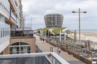 Prachtige appartement op de eerste verdieping van Residentie Chablis. Het spectaculaire uitzicht op de zeedijk en de Noordzee vormt ongetwijfeld de grootste troef van deze eigendom en zorgt elke dag opnieuw voor een ongeëvenaarde woonbeleving. Residentie Chablis behoort bovendien tot één van de recentste residenties op de zeedijk van Middelkerke, waardoor u geniet van een moderne bouwkwaliteit en uitstekende energiescores. Dit maakt het appartement niet alleen bijzonder comfortabel, maar ook toekomstgericht en energiezuinig. De residentie werd ontworpen met slechts één appartement per verdieping en binnenin treft u een moderne en doordachte indeling aan met een lichtrijke leefruimte die uitgeeft op het ruime terras aan de voorzijde, waar u volop kunt genieten van het panoramische zeezicht. De open keuken sluit perfect aan bij de hedendaagse woonstijl en vormt het hart van de leefruimte. Verder beschikt het appartement over twee slaapkamers, die beide rechtstreeks toegang bieden tot het zonnige achterterras. De badkamer is uitgerust met een stijlvolle inloopdouche. Er is en praktische berging voorzien met aansluiting voor een wasmachine en daarnaast tal van inbouwkasten in de hall en slaapkamers. De residentie beschikt over privatieve kelderbergingen voor onder andere fietsen en een afzonderlijk vuilnislokaal. Het appartement wordt bovendien volledig gemeubeld verkocht en bevindt zich in uitstekende staat van onderhoud, waardoor u onmiddellijk kunt genieten van uw tweede verblijf of vaste woonst aan zee.