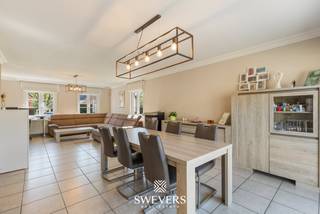 Voor meer info en foto’s, surf naar www.swevers.be – Deze open bebouwing in Helchteren (Ambachtstraat 33B) combineert ruimte, comfort en flexibiliteit. De woning uit 1996 werd goed onderhouden en deels geüpgraded met o.a. zonnepanelen en warmtepompboiler (2016), een nieuwe gasketel (2019) en een pelletkachel (2023). Met een bewoonbare oppervlakte van 225 m² biedt ze plaats voor het hele gezin.<br />Via de inkomhal met gastentoilet bereikt u de lichtrijke leefruimte van ca. 40 m² met zit- en eetgedeelte. Aansluitend ligt de praktische keuken (20 m²) met toegang tot tuin, wasplaats, garage en kelder. De inpandige garage (25 m²) biedt potentieel voor een studio, praktijk of kangoeroewonen gezien hier alle nutsvoorzieningen aanwezig zijn. Boven zijn er drie ruime slaapkamers (25 m² en 2 x 16 m² met inbouwkasten), een zeer ruime badkamer en een extra ruimte die kan dienen als dressing of bureau. Zelfs de overloop biedt ruimte voor een extra bureau of ontspanningsruimte. De kelder (31 m²) zorgt voor extra opslag.<br />Het perceel van 7a 59ca is zuidwest georiënteerd en beschikt over een recent aangelegde, verzorgde tuin met terras en veel privacy. Een bijgebouw van 40 m² biedt extra mogelijkheden als werkplaats of hobbyruimte. Rustig gelegen en toch nabij scholen, winkels (1 km) en vlotte verbinding via de autosnelweg (6 km). Voor meer informatie, bel 011 255 155. Bron bewoonbare oppervlakte: EPC – verslag.