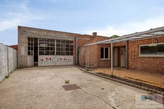 Veelzijdige woning met ruim magazijn (612 m²) op gunstig perceel van 1264 m² te Keerbergen.<br /><br />Deze voormalige Citroën garage bevindt zich net buiten het centrum van Keerbergen, waar winkels, scholen en openbaar vervoer makkelijk bereikbaar zijn. Tevens vlotte verbinding met omliggende gemeenten en autostrades.<br /><br />We betreden de woning langs de voordeur, waarop we in de inkomhal terecht komen. Van hieruit is er toegang tot de leefruimte met zithoek en eetplaats. De ruime tussenkamer geeft enerzijds toegang tot de bergkelder en anderzijds tot de binnenkoer. Achterliggend bevinden zich de te renoveren keuken en badkamer. Terug in de inkomhal, biedt de vast trap connectie met de 1 ste verdieping. Hier zijn nog 2 zéér ruime slaapkamers aanwezig. Makkelijk op te delen in 2 kamers en badkamer.<br /><br />Via de zijdelings gelegen toegangspoort, bereiken we de binnenkoer en vervolgens de voormalige autogarage. Deze ruimte van maar liefst 612 m², is uitermate geschikt voor tal van zelfstandige activiteiten. Bovendien zijn een autobrug, smeerput en spuitkabine reeds aanwezig. Op het verdiep van het magazijn bevinden zich, bureauruimtes, douchekamer en polyvalente (archief/stockage)ruimtes.<br /><br />Achteraan het perceel bevindt zich een ruime tuin, waar u in alle rust kunt genieten van een groene en aangename omgeving.<br /><br />Kortom, de idéale opportuniteit voor wie op zoek is naar een uitzonderlijke locatie om werk en wonen te combineren op één plaats.