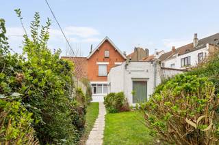 Authentiek karaktervol herenhuis uit 1926, gelegen op een perceel van 295 m² in een rustige residentiële wijk van Ganshoren. Met 248 m² verdeeld over 3 verdiepingen is dit een zeldzame eigendom, ideaal voor een groot gezin of de uitoefening van een vrij beroep — het huis herbergt momenteel een medische praktijk met onafhankelijke wachtkamer en toegang tot de tuin. De gelijkvloerse verdieping biedt een salon, een ruime eetkamer die uitgeeft op een ingerichte keuken met toegang tot het terras. De eerste verdieping telt drie slaapkamers waarvan één met aangrenzende badkamer (bad, dubbele wastafel, WC), evenals een familiesalon. Op de derde verdieping bieden twee grote mansardebureaus met zichtbare dakconstructie, velux en geïntegreerde opbergruimte uitzonderlijk veel licht en mooi vrij uitzicht.<br />Buiten completeren voor- en achtertuin, terras, tuinberging en houten chalet het geheel. De wachtkamer van meer dan 30 m² met apart toilet kan bovendien eenvoudig worden omgevormd tot extra leefruimte. Het huis is uitgerust met 14 zonnepanelen.<br />Ideaal vrij beroep • Kadastraal inkomen: 1.339 € • Vrij bij akte