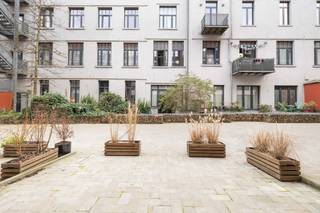 Gesitueerd op enkele minuten van Tour&Taxis vind u dit DUPLEX APPARTEMENT van maar liefst 116m² en 11m² TERRAS. Gelegen op de begane grond in een privatieve steeg van een klein modern gebouw. Inkomhal, 40m² LICHTRIJK WOONKAMER, aparte gastentoilet en eerste berging op de gelijkvloers verdieping. Op de eerste verdieping zijn twee GROTE slaapkamers (14m² & 15m²), 2de berging en ruime badkamer. Super EPC A- met gedeeld gebruik van ZONNEPANELEN en EXTRA HOGE ISOLATIE. Kelder aan te kopen, parking optioneel. Verkoop onderworpen aan registratierechten (12,5%) op de grondwaarde en BTW (21%) op de constructiewaarde. Bezoek nu EXCLUSIEF met TREVI!