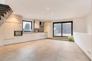 Op zoek naar een woning in Zwijnaarde dan is deze beletagewoning met een doordachte indeling en een uitgesproken architecturaal karakter absoluut uw bezoek waard.Op het gelijkvloers bevinden zich twee volwaardige slaapkamers, ideaal als master bedroom, kinderkamer, bureau of hobbyruimte. Dankzij de praktische indeling geniet deze verdieping van rust en functionaliteit.De eerste verdieping vormt het kloppend hart van de woning. Hier bevindt zich de volledig geïnstalleerde keuken, uitgerust met alle hedendaagse comfort. De keuken paalt rechtstreeks aan het ruime terras en creëert zo een perfecte binnen-buitenbeleving. Dit is dé plek om te koken, te tafelen en gasten te ontvangen.Op de tweede verdieping bevindt zich de royale leefruimte. Deze geniet van uitzonderlijk veel privacy en biedt een aangenaam zicht op het omliggende groen. De grote raampartijen zorgen voor een overvloed aan natuurlijk licht en versterken het open gevoel.De betonnen trappen vormen een echte blikvanger in de woning en zorgen voor een stoer, modern loftgevoel dat perfect aansluit bij de architecturale uitstraling.De woning heeft een mobiscore van 8,3 euro is het pand ideaal gelegen. Het pand ligt andere nabij van het Technologiepark en Tech Lane Ghent EilandINDELING: - Gelijkvloerse verdieping: Inkomhal met gastentoilet, berging, 2 slaapkamers, badkamer, koer en buitenberging- Eerste verdieping: Leefkeuken en ruim terras- Tweede verdieping: Woonkamer