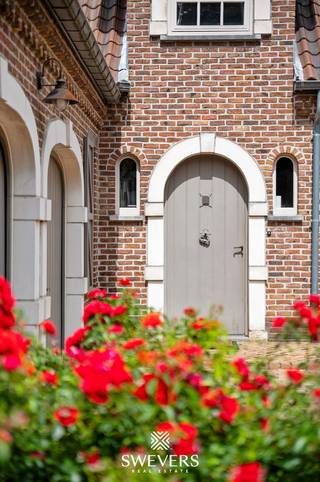 Voor meer info en foto’s, surf naar www.swevers.be – Ontdek deze instapklare open bebouwing aan de Laeremansstraat 21 in Koersel, gelegen op een uitzonderlijk perceel van 1 ha 35 a 73 ca met open zicht op agrarisch gebied. Hier geniet u van maximale privacy, rust en ruimte, terwijl winkels, scholen en andere voorzieningen vlot bereikbaar zijn. De villa, gebouwd in 1988, biedt 302 m² bewoonbare oppervlakte en is kwalitatief afgewerkt met onder meer parketvloeren. Op het gelijkvloers vindt u een ruime inkomhal met gastentoilet, een lichtrijke woonkamer met eetkamer, een volledig uitgeruste keuken met zicht op het overdekte terras, een praktische wasplaats, een slaapkamer en een inpandige dubbele garage. Op de verdieping bevinden zich nog twee ruime slaapkamers, waarvan één met een aparte dressing, twee badkamers en een berging. De royale kelder van ca. 120 m² biedt extra bergruimte en een bijkomende garage of opslagruimte. Dankzij de noordwestelijke oriëntatie geniet u volop van de avondzon. Het uitgestrekte terrein is ideaal voor dierenliefhebbers of het houden van paarden en biedt tal van mogelijkheden. Scholen liggen op 1,3 km, openbaar vervoer op 350 m, winkels en horeca op 2 km en de autosnelweg bereikt u in slechts 7 km. Een unieke eigendom voor wie op zoek is naar ruimte, comfort en een groene omgeving. Voor meer informatie, bel 011 255 155. Bron bewoonbare oppervlakte: EPC – verslag.