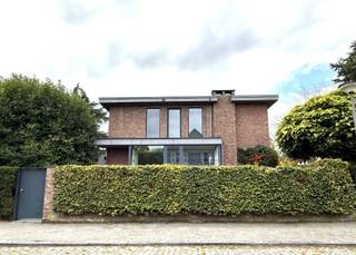 <p><strong>Deze instapklare Half-open bebouwing met een hedendaagse en tijdloze architectuur bevindt zich op een uiterst rustige, groene locatie in Wilrijk in de gegeerde wijk Park den Brandt. De woning wordt omringd door een charmante, onderhoudsvriendelijke tuin die veel privacy biedt en een oase van rust vormt.<br /><br /></strong></p>
<p><span><strong>INDELING:</strong></span><br />Bij het betreden van de woning valt meteen de stijlvolle inkomhal op, afgewerkt met een elegante witmarmeren vloer voorzien van een gastentoilet en vestiaire. De ruime, lichtrijke LEEFRUIMTE baadt in natuurlijk licht dankzij de grote raampartijen en is afgewerkt met een warme parketvloer. De living, salon en eetkamer vormen samen een harmonieus geheel en beschikken over een praktische vaste kastenwand.</p>
<p>De modern ingerichte KEUKEN ca. 5,60m x 2,10m sluit rechtstreeks aan bij de leefruimte en is uitgerust met een granieten werkblad en kwalitatieve SIEMENS-toestellen. Vanuit de keuken is er directe toegang tot het zonnige terras en de groene tuin, ideaal om te genieten op een zonnige dag.</p>
<p>Op de eerste verdieping bevinden zich drie SLAAPKAMERS (7,68m² - 11m² - 5,44m² en 14,64m²) en een bureau, elk afgewerkt met parketvloer en voorzien van een ingemaakte kast. De ruimtes kunnen flexibel worden ingericht als slaapkamers, bureau of hobbykamer. Daarnaast is er een DOUCHEKAMER met douche en een wastafel en een apart toilet.</p>
<p>De woning is volledig onderkelderd en biedt een bijzonder praktische meerwaarde. De kelder beschikt over een technische ruimte, aansluitingen voor wasmachine en droogkast, en voldoende opbergruimte. De kelder heeft een comfortabele stahoogte van 1,88 meter.</p>
<p>Buiten nodigt de gezellige tuin uit tot ontspannen in een groene omgeving met natuurlijke beplanting en volwassen bomen. Het aangename terras sluit naadloos aan bij zowel de leefruimte als de keuken, wat zorgt voor een vloeiende overgang tussen binnen en buiten. Bovendien is er een voorziening voor een fietsenberging.</p>
<p>Tot slot is de woning uitgerust met zonnepanelen, wat bijdraagt aan een energiezuinige en duurzame levensstijl. Deze stijlvolle, instapklare woning combineert hedendaagse elegantie met optimaal wooncomfort op een bijzonder rustige locatie in Wilrijk.<br /><br /></p>
<span><strong>BIJZONDERHEDEN: </strong></span><br />* Gelegen op toplocatie in Wilrijk, omgeving Park den Brandt <br />* EPC 181kWh/m², zonnepanelen aanwezig, fietsenberging