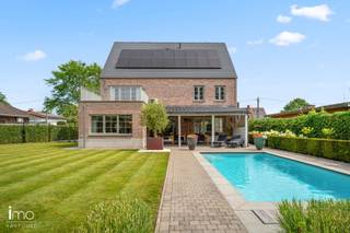In een rustige straat in Rumst, met een prachtig en open zicht op het omliggende groen, bevindt zich deze moderne en energiezuinige villa. De woning werd gebouwd in 2010 en combineert een hoogwaardige afwerking, royale volumes en hedendaags wooncomfort op een prachtig zuidwest gericht perceel van 10a 60ca.<br /><br />Met een bewoonbare oppervlakte van maar liefst 330 m² biedt deze instapklare villa alle ruimte voor een comfortabel gezinsleven. Bovendien werd de woning recent nog energetisch geoptimaliseerd, wat resulteert in een bijzonder energiezuinige en toekomstgerichte woning, voorzien van airco's, zonnepanelen, thuisbatterij en laadpaal.<br /><br />Via de ruime inkomhal betreedt u de lichtrijke leefruimte, waar grote raampartijen en hoogwaardige materialen zorgen voor een luxueuze en aangename woonbeleving. Aansluitend bevindt zich de volledig geïnstalleerde keuken, uitgerust met onder meer een wijnfrigo en een kwalitatief gasvuur. De keuken geeft rechtstreeks toegang tot het volledig overdekte terras, waar u in alle rust kunt genieten van het uitzicht over de zonnige tuin en het zwembad. Verder beschikt het gelijkvloers over een ruime wasplaats, berging en inpandige garage.<br /><br />Op de eerste verdieping bevinden zich vier volwaardige slaapkamers, twee badkamers, waarvan één met sauna, en een ensuite dressing. De master bedroom beschikt bovendien over een eigen balkon. Ook de tweede verdieping werd volledig ingericht en biedt tal van mogelijkheden. Deze verdieping kan dienen als twee ruime slaapkamers, maar leent zich eveneens uitstekend als ruime bureau-, hobby- of polyvalente ruimte.<br /><br />Deze moderne villa combineert een uitstekende ligging met een hoogwaardige en luxueuze afwerking, uitstekende energetische prestaties en een prachtige groene omgeving. Een volledig instapklare woning waar comfort, kwaliteit en privacy centraal staan.<br /><br />Voor meer informatie of een bezoek kunt u ons steeds contacteren op het nummer 015/21.21.21 of via olivier.lievens@imovastgoed.be.<br />Vraagt u zich af wat uw eigen woning waard is? Neem dan gerust contact op voor een gratis waardebepaling.