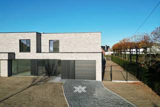 Deze nieuwbouw woning met 3 slaapkamers en een bewoonbare oppervlakte van 187 m² is gelegen op een perceel van 578 m² langs de Rijksweg in Machelen, een deelgemeente van Zulte. Deze gemeente is centraal gelegen tussen Deinze en Kortrijk en staat bekend om zijn mooie natuur en uitgestrekte fiets- en wandelroutes langs het water, waardoor het erg geliefd is bij fietsers, wandelaars en natuurliefhebbers. Daarnaast biedt de regio een mooi aanbod aan horeca, diverse supermarkten, detailhandel, sportfaciliteiten,...<br /><br />De woning is op het gelijkvloers ingedeeld als volgt: een inkomhal met gastentoilet en plaats voor een vestiairekast, via de kamerhoge glazen deur (type steellook) komt u in de lichtrijke eet- en leefruimte met volledig geïnstalleerde open keuken, voorzien van een keukeneiland en uitgerust met diverse inbouwtoestellen waaronder een Bora fornuis met ingewerkte dampkap. Aansluitend aan de keuken bevindt zich een inpandige garage met ruime annex berging. De westelijk georiënteerde tuin met terras is te bereiken vanuit de leefruimte. Dankzij de grote raampartijen kunt u binnen genieten van een mooie natuurlijke lichtinval en een uitzicht over de tuin.<br /><br />Op de eerste verdieping zijn er drie slaapkamers, samen met een extra afzonderlijk toilet, een technische ruimte en een badkamer voorzien van een ligbad, ruime inloopdouche en een dubbele wastafel.<br /><br />Deze woning maakt deel uit van een kleine verkavelde grond waarop er 6 nieuwbouwwoningen zullen komen. Twee woningen werden ondertussen volledig afgewerkt, twee andere zitten in ruwbouwfase en er zijn ook nog twee woningen waar de bouwwerken nog moeten starten. In de laatste twee gevallen kunnen alle keuzes op het vlak van afwerking nog zelf gemaakt worden volgens de ruime budgetten die in het lastenboek standaard worden voorzien.<br /><br />Deze woningen voldoen aan de strenge energetische normen en onderscheiden zich onder meer door hun duurzaam karakter, vrij van fossiele brandstoffen. Er wordt gebruik gemaakt van fotovoltaïsche panelen (4 stuks), vloerverwarming door middel van een warmtepomp (lucht-water) en een sterke akoestische en thermische isolatie. Bovendien worden de woningen uitgerust met een ventilatiesysteem type D met maximale warmterecuperatie. Iedere woning beschikt tevens over een septische put van 2.000 liter en een regenwaterput van 10.000 liter.<br /><br />Lot 3: oppervlakte perceel 336 m² - bewoonbare oppervlakte 187,26 m²<br />Lot 4: oppervlakte perceel 501 m² - bewoonbare oppervlakte 173,70 m²<br />Lot 5: oppervlakte perceel 703 m² - bewoonbare oppervlakte 184,04 m²<br />Lot 6: oppervlakte perceel 578 m² - bewoonbare oppervlakte 186,99 m²<br /><br />Verlaagd BTW-tarief van 6% mogelijk op de volledige constructiewaarde. <br /><br />Benieuwd naar één van deze lichtrijke en kwalitatieve nieuwbouwwoningen? Maak dan snel een vrijblijvende afspraak via guillian@landbergh.be of 09 278 78 79