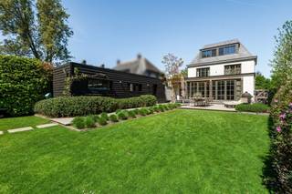 <p><span>Gelegen aan een prachtige laan op loopafstand van het bruisende centrum van Hoogstraten ligt deze volledig gerenoveerde villa op een perceel van ca. 900 m².</span></p><p><span> </span></p><p><span>Indeling</span></p><p><span>U komt binnen in de entréehal met gastentoilet en trap naar de verdieping. Vanuit de hal toegang tot de keuken met aansluitend de ruime eetkamer / orangerie met zicht op de tuin en toegang tot het terras. De living is verdeeld in een TV kamer aan de voorzijde en een centrale zitkamer welke aansluit op de eetkamer, beiden op eiken parket. De zitkamer is tevens voorzien van een open haard op gas en heeft een open verbinding naar de eetkamer / leefkeuken. Dankzij twee dubbele tuindeuren kan de achtergevel vrijwel volledig worden geopend naar het terras. De keuken is voorzien van diverse inbouwtoestellen, de eetkamer beschikt nog over een gashaard, vloerverwarming en airconditioning. Vanuit de leefkeuken ook toegang tot de achteringang met vestiaireruimte.</span></p><p><span> </span></p><p><span>1e Verdieping</span></p><p><span>De nachthal met afzonderlijk toilet geeft uit op drie ruime slaapkamers waarvan twee met ingemaakte kasten, en een badkamer met ruime inloopdouche en dubbele lavabo. </span></p><p><span> </span></p><p><span>2e Verdieping</span></p><p><span>Op de bovenste verdieping bevindt zich de masterbedroom bestaande uit een dressingkamer met ingemaakte kasten, slaapkamer voorzien van airconditioning en een ruime badkamer voorzien van ligbad, inloopdouche, toilet en dubbele lavabo.</span></p><p><span> </span></p><p><span>Kelder</span></p><p><span>De woning is volledig onderkelderd met een bergruimte voorzien van voorraadkasten, een royale wasruimte met aansluitingen voor wasmachine en droger, een kleine wijnkelder alsook een speelkamer en een bergkelder. Deze "leefruimtes" in de kelder hebben daglicht en verwarming. </span></p><p><span> </span></p><p><span>Garage</span></p><p><span>De vrijstaande garage is voorzien van een automatische poort en biedt voldoende ruimte. </span></p><p><span> </span></p><p><span>Tuin en buitenruimtes</span></p><p><span>De tuin is prachtig aangelegd met ruime terrassen in blauwe steen en is omheind. Perfecte Zuid-oriëntatie! Achterin de tuin bevindt zich nog een "tuincafé" met ingerichte bar en een toilet. Aan de voorzijde van de woning zijn meerdere parkeerplaatsen voorzien alsook een aansluitpunt voor opladen van voertuigen.</span></p><p><span> </span></p><p><span>Bijzonderheden</span></p><p><span>In 2021 is deze woning volledig gerenoveerd met oog voor detail en aandacht voor technische duurzaamheid. </span></p><p><span>De woning is voorzien van hedendaags comfort zoals een uitgebreid alarmsysteem, camerabewaking, airconditioning, zonnepanelen, etc.</span></p><p><span> </span></p><p><span>Meer inlichtingen via ons kantoor.</span></p>