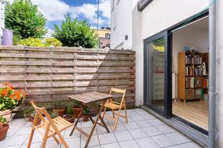 Omgeving<br /><br />In de aangename en rustige Dendermondstraat, vlakbij de Troonplaats vinden we deze charmante woning terug. De woning springt meteen in het oog dankzij haar karaktervolle en charmante gevel, die het pand een authentieke uitstraling geeft. Tegelijk geniet u hier van een vlotte bereikbaarheid en de nabijheid van winkels, openbaar vervoer, belangrijke invalswegen en het bruisende stadsleven. <br /><br /> Indeling<br /><br />De woning is momenteel ingericht in 2 afzonderlijke appartementen, die beide verhuurd zijn.<br /><br />Op het gelijkvloers bevindt zich het eerste appartement. Dit beschikt over een leefruimte, keuken, badkamer en 1 slaapkamer. Achteraan is er bovendien een koer, een aangename extra buitenruimte.<br /><br />Het tweede appartement strekt zich uit over de eerste en tweede verdieping en is ingericht als duplex. Op de eerste verdieping bevindt zich de ruime leefruimte met open keuken. Achteraan vinden we de badkamer en een bijkomende ruimte die momenteel als stockageruimte wordt gebruikt. Er is ook een terras aanwezig op de eerste verdieping. <br /><br />Op de bovenste verdieping bevinden zich nog 2 slaapkamers.<br /><br />Momenteel bedraagt de totale maandelijkse huurprijs 1570 euro. <br /><br />Troeven<br /><br />- TOP buurt met gezellige barretjes <br />- Momenteel verhuurd<br />- Ruime slaapkamers<br />- Grote kelder<br /><br />Verplichte vermeldingen<br /><br />- EPC: 311 kWh/m²<br />- P-score C<br />-G-score C<br />Stedenbouwkundige inlichtingen: in aanvraag.