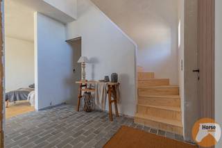 <p><span><strong>LEDE - Exclusieve landelijke woning op unieke ligging</strong><br />EERSTE BEZOEKDAG ZATERDAG 23 MEI VAN 09u TOT 13u (Enkel op afspraak !)<br /></span><br />In het rustige en groene Stichelendries te <span><span>Lede</span></span> bevindt zich deze uitzonderlijke woning van 2025, gelegen op een ruim perceel van maar liefst 5.550 m². Dankzij de open ligging, de prachtige verzichten over het omliggende landschap en de absolute privacy geniet u hier dagelijks van rust, ruimte en natuur in een exclusieve woonomgeving.</p>
<p>Deze stijlvolle villa werd ontworpen in een tijdloze landelijke architectuur en opgetrokken in traditioneel metselwerk met hoogwaardige materialen. De woning combineert authenticiteit en charme met hedendaags wooncomfort en energiezuinige technieken. Bovendien biedt de huidige afwerkingsfase de unieke kans om nog persoonlijke accenten en afwerkingen naar eigen smaak toe te voegen, zodat u deze woning volledig kan afstemmen op uw woonwensen.</p>
<p>Via de royale inkomhal met gastentoilet en elegante traphal wordt u verwelkomd in de bijzonder lichtrijke leefruimte. Grote raampartijen zorgen voor een overvloed aan natuurlijk licht en creëren een prachtig zicht op de omliggende tuin en het achterliggende groen. De gezellige houtkachel vormt het warme hart van de woning en zorgt voor een sfeervolle en uitnodigende leefomgeving. Aansluitend bevindt zich het deels overdekte terras, waar u in alle rust kan genieten van lange zomeravonden en het weidse uitzicht.</p>
<p>De leefruimte staat in directe verbinding met de bureauruimte, ideaal voor thuiswerk of een praktijk aan huis, en met de ruime open keuken. Deze keuken biedt tal van mogelijkheden voor een stijlvolle inrichting en wordt aangevuld met een praktische berging/wasruimte die extra comfort en opbergruimte voorziet.</p>
<p>Op de eerste verdieping bevindt zich de ruime master bedroom met aansluitende dressing, een tweede volwaardige slaapkamer en een royale badkamer uitgerust met ligbad en de mogelijkheid tot het installeren van een douche. Verder vindt u hier nog een apart toilet en een extra berging. De polyvalente leefkelder biedt bijkomende mogelijkheden en kan perfect ingericht worden als derde slaapkamer, hobbyruimte, fitness, speelkamer of extra bureau.</p>
<p>Ook technisch voldoet deze woning aan de hedendaagse normen inzake comfort en energiezuinigheid. Zo werd de woning uitgerust met vloerverwarming, een energiezuinige warmtepomp lucht/lucht, ventilatiesysteem D, aluminium/houten ramen met hoogrendementsglas en een regenwaterput van 10.000 liter. Het EPB Nieuwbouwattest is momenteel in opmaak.</p>
<p>Buiten werd de tuin recent ingezaaid en geniet u van een prachtig groen kader rondom de woning. Daarnaast is er reeds een tuinberging aanwezig en bestaat de mogelijkheid om een carport te voorzien. Voor de verdere afwerking zijn bovendien reeds kwalitatieve materialen aanwezig, waaronder stijlvolle eiken binnendeuren en blauwe steen terrastegels.</p>
<p>Bent u op zoek naar een exclusieve woning met karakter, ruimte en een unieke ligging in het groen? Aarzel dan niet om ons te contacteren op 053/60.65.66 voor meer informatie of een bezoek ter plaatse en ontdek zelf de charme en mogelijkheden van deze uitzonderlijke eigendom.<br />De prijs is een niet-bindende richtprijs. Na biedingen beslist de verkoper over verkoop aan het beste bod. Info via ons of reglement.</p>