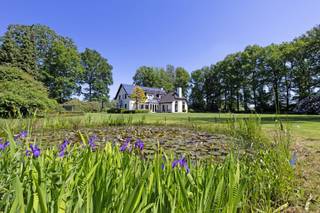 <p><span>Deze karaktervolle woning biedt een unieke combinatie van ruimte, rust en privacy in een groene en landelijke omgeving. Gelegen op een prachtig zuidgericht perceel van maar liefst 2ha 48a 40ca geniet u hier van een uitzonderlijk gevoel van vrijheid en een open zicht op de omliggende weilanden.<br /><br /></span></p><p><span>De woning werd gebouwd in 1980 en in 2003 uitgebreid met een bijkomende aanbouw. Doorheen de jaren werd ze steeds goed onderhouden en afgewerkt met kwalitatieve materialen, wat duidelijk voelbaar is in de aangename en verzorgde sfeer die het huis uitstraalt. Bovendien is de volledige eigendom vergund.</span></p><p><span> </span></p><p><span>Bij het betreden van de woning komt u binnen in de inkomhal met gastentoilet, waarna u wordt verwelkomd in de ruime en gezellige leefruimte. Deze bestaat uit een woonkamer, TV-hoek, eetplaats en bureelhoek, waardoor er een aangename indeling ontstaat die zowel praktisch als huiselijk aanvoelt. Aansluitend bevindt zich de lichtrijke tuinkamer met prachtig zicht op de tuin en het omliggende groen. De keuken, bijkeuken/wasplaats en toegang tot de kelder maken het gelijkvloers compleet en functioneel.<br /><br /></span></p><p><span>Op de verdieping geeft de nachthal toegang tot vier volwaardige slaapkamers, een badkamer en een zolderberging. De woning beschikt daarnaast over een dubbele inpandige garage met extra zolderruimte.</span></p><p><span> </span></p><p><span>Ook de buitenomgeving is een absolute troef. De aangelegde tuin met vijver, het overdekte terras en het tuinhuis creëren een aangename plek om te genieten van de rust. De omliggende weilanden versterken het gevoel van ruimte en bieden tal van mogelijkheden voor dierenliefhebbers of wie gewoon wil genieten van volledige privacy.<br /><br /></span></p><p><span>Extra comfort wordt geboden door onder andere zonnepanelen, verwarming op stookolie, houtkachels, parketvloeren, houten ramen, sierradiatoren en een alarmsysteem. Alles samen maakt dit een woning die zowel karaktervol als praktisch is, en bovendien zeer goed onderhouden werd.</span></p><p><span> </span></p><p><span>De ligging, de uitzonderlijke perceelgrootte, de zuidoriëntatie en de totale privacy maken van deze eigendom een zeldzame kans voor wie op zoek is naar landelijk wonen op hoog niveau.</span></p>