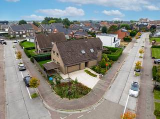 In een rustige woonwijk, op wandelafstand van het station, vinden we op een mooi hoekperceel deze uitzonderlijk ruime gezinswoning met maar liefst 7 slaapkamers.<br /><br />De villa werd opgetrokken in de jaren tachtig, met één duidelijke focus: ruimte voor het hele gezin. Dat vertaalt zich vandaag in royale leefruimtes, een bijzonder praktische indeling en heel wat mogelijkheden om de woning naar eigen smaak te moderniseren.<br /><br />Via de ruime inkomhal met ingebouwde vestiairekast betreden we de woning. Rechts bevindt zich een afzonderlijke zitruimte, die aansluit op de ruime, tweedelige leefruimte. Verder vinden we een grote, aparte leefkeuken met aansluitend een bijzonder praktische en ruime koele berging.<br /><br />Naast de keuken bevinden zich de ingerichte wasberging en een eerste badkamer met douche. Van hieruit is er rechtstreeks toegang tot de dubbele garage, die zowel langs de voor- als achterzijde bereikbaar is.<br /><br />De verschillende leefruimtes op het gelijkvloers zijn vandaag afzonderlijk ingedeeld, maar bieden dankzij hun oppervlakte en indeling heel wat potentieel. Wie houdt van een hedendaags en open ruimtegevoel kan hier verschillende ruimtes samenbrengen tot één royale leefomgeving.<br /><br />Ook op de eerste verdieping blijft ruimte het sleutelwoord. Hier bevinden zich maar liefst 7 slaapkamers, een tweede badkamer, een afzonderlijk toilet en een extra berging. Een uitzonderlijke indeling die deze woning bijzonder geschikt maakt voor grote of nieuw samengestelde gezinnen, maar evengoed voor wie nood heeft aan extra bureel, hobby of logeerruimte.<br /><br />Buiten geniet u van een aangenaam aangelegde tuin met terras. Dankzij het hoekperceel is er bovendien een mooi gevoel van ruimte rondom de woning. Parkeren kan op eigen terrein en bijkomend in de straat.<br /><br />Bent u op zoek naar een bijzonder ruime gezinswoning met 7 slaapkamers, een dubbele garage en tal van mogelijkheden, en dit op een centrale maar rustige ligging? Dan verdient deze woning absoluut uw bezoek.<br /><br />Extra troeven:<br /><br />Maar liefst 7 slaapkamers<br /><br />Dubbele garage<br /><br />Ruime en veelzijdige leefruimtes<br /><br />Drijfkracht aanwezig<br /><br />Regenwaterput van 10.000 liter<br /><br />Aangename tuin en terras<br /><br />Parkeermogelijkheden op eigen terrein