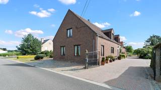 TIELT-WINGE- Ruime woning met bijgebouwen en binnenkoer op 96a<br /><br />Gelegen in het landelijke Sint-Joris-Winge vinden we deze ruime woning met bijgebouwen en een schuur. Een eigendom met een stevige basis en tal van mogelijkheden voor wie op zoek is naar ruimte, rust en een landelijke omgeving.<br /><br />De woning is te renoveren, maar beschikt over een degelijke constructie en biedt dankzij de ruime plaatsen heel wat potentieel. Op het gelijkvloers komen we binnen in een ruime inkomhal met apart toilet, een bureel of slaapkamer en een badkamer. Verder vinden we een ruime leefruimte met eetplaats, aansluitend een grote keuken. Achter de keuken bevindt zich een zij-ingang met aansluitend een was- en bergruimte.<br /><br />De verdieping biedt maar liefst vier zeer ruime slaapkamers, aangevuld met verschillende bergplaatsen, een badkamer en een apart toilet.<br /><br />Aansluitend aan de woning bevindt zich een grote schuur die mits renovatie kan worden ingericht als polyvalente ruimte, bureel, hobbyruimte of stalling. Rond de binnenkoer bevinden zich daarnaast verschillende stalgebouwen en een ruime schuur. Hoewel ook deze gebouwen renovatie vragen, bieden ze bijzonder veel mogelijkheden voor opslag, het houden van dieren of andere doeleinden.<br /><br />Achter de gebouwen strekt het weiland zich volledig open uit. Mits het verwijderen van enkele bijgebouwen kan bovendien een prachtig open zicht vanaf de binnenkoer en eventueel woning worden gecreëerd, wat de landelijke sfeer van het geheel nog verder versterkt.<br /><br />Deze eigendom is dan ook bijzonder geschikt voor wie op zoek is naar een ruime woning met veel bijgebouwen, opslag en grond, en dit in een rustige, landelijke omgeving.<br /><br />Bent u op zoek naar een ruime landelijke woning met karakter en tal van mogelijkheden? Dan is deze eigendom zeker een bezoek waard. Aarzel niet om ons te contacteren: 053/60.65.66.