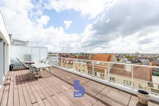 Ruimte, licht en een uitzonderlijk terras op een toplocatie. Dit prachtige duplex penthouse is gelegen op de 4de verdieping van de klassevolle residentie ‘Fusion’, een recente residentie uit 2008. Dankzij de centrale ligging bevinden winkels, openbaar vervoer, het strand en belangrijke invalswegen zich allemaal binnen handbereik.<br /><br />Met maar liefst 133 m² bewoonbare oppervlakte, drie slaapkamers en een riant, zonovergoten terras biedt dit penthouse een uitzonderlijk gevoel van ruimte en comfort.<br /><br />Bij het binnenkomen ervaar je meteen het WOW-effect. De bijzonder lichtrijke woonkamer baadt in het zonlicht en geniet rondom van terrassen, waardoor binnen en buiten hier perfect in elkaar overvloeien.<br /><br />De aangename parketvloer zorgt voor een warme en stijlvolle uitstraling. Er is voldoende ruimte voor een ruime zithoek en een aparte eetruimte, terwijl de grote keuken aansluit op de leefruimte en bovendien beschikt over een extra berging.<br /><br />De nachthal geeft toegang tot drie volwaardige slaapkamers, een badkamer met comfortabele inloopdouche en een apart toilet.<br /><br />Maar de absolute troef van dit penthouse is zonder twijfel het riante terras. Hier geniet je volop van de zon, de openheid en het mooie zicht rondom. Op heldere dagen reikt het zicht zelfs tot aan de zee in de verte. Een heerlijke plek om te ontbijten in de ochtendzon, lang te tafelen met vrienden of simpelweg te genieten van de rust en het uitzicht.<br /><br />De combinatie van de royale bewoonbare oppervlakte, de overvloedige lichtinval, de verschillende terrassen, drie slaapkamers en de uitstekende ligging maakt van dit duplex penthouse een bijzonder aangename woonst. Bovendien geniet je in deze recente residentie van een uitstekend EPC-label B en zijn er een gemeenschappelijke fietsenberging en afvalberging aanwezig.