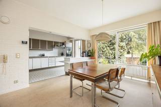 <p><span>Droom je van een woning met karakter én ruimte, waar architectuur, design en natuur samenkomen? Dan is deze unieke bel-etage aan de statige Collegelaan een buitenkans. De indrukwekkende leefruimte, authentieke sierelementen uit het laat modernisme, vier slaapkamers, een polyvalent gelijkvloers en de gezellige tuin maken van dit huis een echte blikvanger. En het Rivierenhof? Dat ligt letterlijk op het einde van de straat.</span><span> </span></p><p><span> </span></p><h3><span>Architectuur met een ziel</span></h3><p><span>Zodra je de woning binnenstapt, voel je dat dit geen doorsnee gezinswoning is. De ruime inkomhal met ingemaakte vestiairekasten geeft toegang tot de inpandige garage, een technische ruimte én een polyvalente ruimte die vandaag perfect dienst kan doen als hobbyruimte, praktijk, thuiswerkplek of zelfs kangoeroewoning. Dankzij de rechtstreekse verbinding met de tuin en de aanwezige sanitaire voorzieningen zijn de mogelijkheden hier eindeloos. </span></p><p><span>Via de iconische, stalen draaitrap — een architecturale eyecatcher die vandaag haast onbetaalbaar zou zijn om opnieuw te realiseren — bereik je de leefverdieping. Hier opent zich een indrukwekkende leefruimte van maar liefst ca. 70 m², waar grote raampartijen, hoge plafonds en de warme materiaalkeuze voor een uitzonderlijk gevoel van ruimte zorgen. De open haard vormt het sfeervolle middelpunt van de zithoek, terwijl de eetkamer naadloos overloopt in de keuken. Het maatwerkmeubilair en de originele architecturale details werden doorheen de jaren met veel zorg bewaard en geven de woning een tijdloze uitstraling.</span></p><p><span>De open keuken ademt dezelfde authentieke sfeer, maar werd tegelijk praktisch geüpdatet met kwalitatieve Miele-toestellen, waaronder een nieuwe oven, koelkast en vaatwasser. Vanuit de eetkamer stap je rechtstreeks het zonnige terras op, waar je uitkijkt over de groene tuin.</span></p><p><span> </span></p><h3><span>Vier slaapkamers en een zee van licht</span></h3><p><span>Op de tweede verdieping brengt de centrale overloop je naar vier slaapkamers, twee badkamers en een apart gastentoilet. Opnieuw speelt natuurlijk licht hier de hoofdrol dankzij de grote ronde lichtkoepel boven de hal.</span></p><p><span>De master bedroom beschikt over een ensuite badkamer met dubbele lavabo, ligbad en sfeervolle blauwe betegeling. Daarnaast zijn er nog twee ruime slaapkamers en een vierde kamer die perfect kan dienen als kinderkamer, bureau of dressing. Dankzij de grote ramen geniet elke kamer van veel licht en een mooi uitzicht op het omliggende groen.</span></p><p><span> </span></p><h3><span>Tuin vol privacy, midden in de stad</span></h3><p><span>Het terras sluit naadloos aan op de leefruimte en vormt de ideale plek voor een ontbijt in de ochtendzon of een gezellige barbecue met vrienden. Via de trap bereik je de fijne tuin, waar volwassen bomen, groen en volledige privacy zorgen voor een oase van rust. Kinderen hebben hier alle ruimte om te spelen, terwijl volwassenen genieten van het groene uitzicht.</span></p><p><span> </span></p><h3><span>Rivierenhof letterlijk om de hoek</span></h3><p><span>De ligging is zonder meer uitzonderlijk. Je woont op de statige Collegelaan, één van de meest gegeerde locaties van Borgerhout, met het Rivierenhof letterlijk op het einde van de straat. Wandelen, sporten of picknicken doe je in één van de mooiste parken van Antwerpen. Winkels, scholen, openbaar vervoer en een Velo-station bevinden zich allemaal op wandelafstand. Bovendien bereik je via de Ring of de autosnelweg in enkele minuten elke uithoek van de stad.</span></p><p><span> </span></p>
