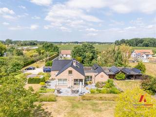 Op een riante kavel van meer dan 1 hectare in Stevoort bevindt zich deze uitzonderlijke villa. Deze in 2011 volledig gerenoveerde en uitgebreide woning uit 1965 verenigt modern wooncomfort met uitgebreide faciliteiten voor paardenliefhebbers.<br />Interesse? Neem contact op met Lieve & Edwin 0475 407673<br /><br />Bij binnenkomst wordt u direct omarmd door de royale inkomhal, waar stijlvolle maatwerkinbouwkasten en een sfeervolle entree de toon zetten voor de rest van deze hoogwaardige woning. <br /><br />De ruime living baadt in natuurlijk licht en is voorzien van airconditioning en comfortabele vloerverwarming en cassettehaard. De keuken biedt alle ruimte voor culinaire experimenten, met uitgebreide opbergmogelijkheden en royale werkbladen. Een praktische technische berging(ruimte voor wasmachine/droogkast) met maatwerkinbouwkasten en een Amerikaanse koelkast/vriezer zorgt voor optimale opslagruimte.<br /><br />Op het gelijkvloers bevinden zich 2 slaapkamers met individueel sanitair en toilet.<br /><br />Interessant aan deze woning is het multifunctionele bureel op het gelijkvloers, dat is voorbereid als home-cinema/tv ruimte. <br /><br />Op de eerste verdieping vindt u een luxueuze master bedroom met eigen badkamer en ruime inloopkast. 1bijkomende slaapkamer. Deze bieden optimale privacy voor het hele gezin. Een bijzonder element is het moderne bureel met open karakter, dat uitkijkt over de leefruimte - perfect voor thuiswerken met behoud van connectie met het gezinsleven.<br /><br />Het buitenterrein is een waar paradijs voor paardenliefhebbers. Met een mogelijkheid tot paardenstalling en een weide van meer dan 1 hectare, palend aan de tuin, biedt deze locatie alle faciliteiten voor het houden van paarden.<br /><br />Praktische Details<br />•Perceeloppervlakte woning: 150,42are + paardenweide van > 1ha<br />•4 slaapkamers<br />•3 badkamers<br />•3 separate toiletten<br />•Uitgebreide bergruimtes met maatwerk inbouwkasten<br />•3 afsluitbare bijgebouwen met zolder, garage, carport, houtopslag <br />•Volledig gerenoveerd met hoogwaardige materialen<br />•Energiezuinige voorzieningen<br /><br />Stevoort combineert landelijk wonen met stedelijk comfort. De rustige, kindvriendelijke omgeving ligt op korte afstand van Hasselt, het klaverblad Lummen, met alle voorzieningen zoals scholen en winkels binnen handbereik.<br /><br />Meer Informatie<br />Voor een persoonlijke bezichtiging van deze unieke woning kunt u contact opnemen met <br />Edwin op 0475 40 76 73 of via admin@verkoopanders.be. <br />VerkoopAnders staat 7 dagen per week voor u klaar vanuit ons kantoor aan de <br />Genkersteenweg 402C in Hasselt.<br />Deze woning verenigt luxe, comfort en functionaliteit op een unieke manier. Of u nu paardenliefhebber bent, houdt van natuur en rust, of gewoon op zoek bent naar een ruime gezinswoning met alle moderne voorzieningen - deze villa biedt het allemaal.<br />Bezoek www.verkoopanders.be voor meer informatie en beeldmateriaal van deze bijzondere woning.<br />