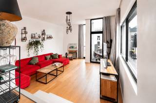 <p>Met het Eilandje op wandelafstand bevindt zich, op de derde verdieping van een gebouw met lift, dit ruime en lichtrijke appartement van ca. 120 m². Het beschikt over 2 slaapkamers en een royaal terras van maar liefst 27 m².<br /><br /><span><strong>INDELING</strong></span>:<br /><br />Via het aparte inkomhalletje betreden we het appartement, dat een aangename scheiding vormt tussen de leef- en slaapruimtes.<br /><br />De royale leefruimte vormt het hart van het appartement en biedt moeiteloos plaats aan een ruime zit- en eetkamer. Grote raampartijen zorgen voor een aangename lichtinval en versterken het open ruimtegevoel.<br /><br />Aansluitend bevindt zich de open, volledig uitgeruste keuken, voorzien van kwalitatieve SMEG-toestellen, veel werk- en opbergruimte én een handgesneden tegelwand.<br /><br />De houten parketvloer geeft het geheel extra warmte en karakter. Met een opschuur- en opfrisbeurt kan deze opnieuw als nieuw worden afgewerkt. Hiervoor werd reeds een offerte opgevraagd van ca. €5.300 incl. btw.<br /><br />Verder beschikt het appartement over 2 slaapkamers, een badkamer met wastafelmeubel en toilet, een afzonderlijke inloopdouche met regendouche én een apart gastentoilet.<br /><br />Dé blikvanger? Het 27 m² grote terras: een volwaardige buitenruimte met plaats voor zowel een grote eettafel als een gezellige loungehoek. Een zeldzame troef midden in de stad.<br /><br /><span><strong>BIJZONDERHEDEN</strong></span>:<br /><br />- Zuidgericht terras<br />- Zeer ruim en energiezuinig appartement<br />- Volledig uitgeruste keuken met SMEG-toestellen<br />- Lift, fietsenberging en gemeenschappelijke kelder</p>