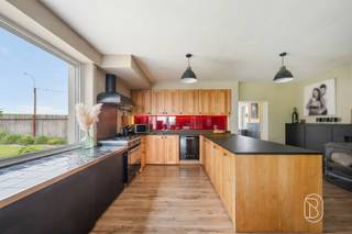 Te koop: karaktervolle woning met loods van 240 m² in OrroirIn Orroir, aan de voet van de Kluisberg, bevindt zich deze robuuste halfopen woning met royale volumes, een grote loods en ruime parkeermogelijkheden.De eigendom combineert comfortabel wonen met tal van mogelijkheden voor opslag, hobby of professionele activiteiten.Wat maakt dit pand uniek?Via de inkomhal komt u in de lichtrijke open leefruimte, die aansluit op de volledig uitgeruste keuken met eetplaats. Verder beschikt het gelijkvloers over een bureau, een praktische wasruimte/berging, een apart toilet en een bijkomende ruimte die ingericht kan worden als douchekamer. Daarnaast is er een grote droge kelder en een rechtstreekse toegang tot de loods. Op de verdieping bevinden zich drie ruime slaapkamers en een uitgeruste badkamer. De zolderverdieping biedt bovendien nog extra potentieel en kan verder ingericht worden als bijkomende kamer(s).Buiten geniet u van een mooi aangelegde en volledig omheinde tuin met twee terrassen. De eigendom beschikt daarnaast over parkeergelegenheid voor meerdere voertuigen en een grote loods van ca. 240 m² met sectionale poort.Technisch is de woning uitgerust met 24 zonnepanelen, dubbele beglazing in PVC, rolluiken, twee regenwaterputten van telkens 5.000 liter en een hydrofoorgroep.Voor wie is dit ideaal?Ideaal voor gezinnen, zelfstandigen of ruimtezoekers die wonen willen combineren met opslag, atelier of professionele activiteit, in een groene omgeving nabij de Kluisberg.Te koop via Immo Beguin, jouw vastgoedexpert sinds 2009, met kantoren in Ronse, Waregem, Kortrijk, Deinze, Doornik en Lessines.Meer info of bezoek via loicvdv@immobeguin.be