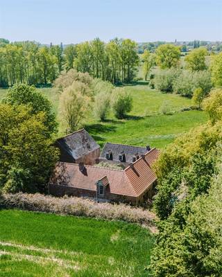 <h3><span>FLOBECQ | Authentieke hoevewoning met atelier, schuur en 9.470 m² grond</span></h3><p><span>Bent u op zoek naar een karaktervolle hoevewoning op een uitzonderlijke locatie, met ruimte voor wonen, werken of een nieuw project? Dan is deze authentieke hoeve in Flobecq, waar stilte, ruimte en rust samenkomen, beslist een bezoek waard.</span></p><p><span>Achter de dubbele toegangspoort bevindt zich een sfeervol binnenhof, omringd door de drie vleugels van de hoeve. De eerste vleugel doet vandaag dienst als inspirerend kunstatelier: een indrukwekkende, open ruimte tot in de nok, met mezzanine, open haard en toegang tot de kelder. Een plek waar creativiteit alle ruimte krijgt.</span></p><p><span>In de centrale vleugel vindt u het hart van de woning: de gezellige leefruimtes met authentieke charme en open haard, de keuken, badkamer, slaapkamer en bergruimte. De derde vleugel omvat momenteel opslagruimtes, een veranda, wasplaats en technische ruimte. Ook de grote ruimtes op de verdieping wachten op een nieuwe invulling en kunnen volledig naar wens worden ingericht. Extra kamers, een gastenverblijf, een cohousingproject. </span></p><p><span>Naast de hoeve bevindt zich een imposante schuur vol potentieel voor hobby, opslag, ambachtelijke of professionele activiteiten.</span></p><p><span>Op een glooiend perceel van maar liefst 9.470 m² wisselen tuin, boomgaard, weide en bos elkaar af, met een uitzonderlijke vegetatie waaronder een majestueuze lindeboom. Dankzij de unieke ligging geniet u hier van maximale privacy, waar rust geen luxe maar een vanzelfsprekendheid is en elke dag als vakantie aanvoelt.</span></p><p><span>Deze eigendom is een levensstijl, een plek waar wonen, werken, creëren en genieten moeiteloos samenvloeien.</span></p><p><span>Troeven:</span></p><ul><li><span>Authentieke driegevel-hoeve met sfeervol binnenhof </span></li><li><span>Unieke landelijke ligging met absolute privacy </span></li><li><span>Atelier en grote schuur met tal van mogelijkheden </span></li><li><span>Perceel van 9.470 m² met tuin, weide en bos </span></li><li><span>Grotendeels vernieuwde en geïsoleerde daken </span></li><li><span>Potentieel voor co-housing, B&B, combi wonen-werken</span></li><li><span>Gelegen nabij wandel- en fietsknooppunten </span></li></ul><h3><span>Richtprijs: 995.000</span><span>.</span></h3>