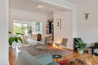 <p><strong>Wonen met klasse, comfort en karakter</strong></p>
<p></p>
<p><strong>Welkom in het hart van Deurne Zuid, waar het beste van twee werelden samenkomt: groen en ruimte, maar ook alle gemak van de stad binnen handbereik. Hier woon je op wandelafstand van de tramhalte, met de Colruyt en het Rivierenhof als achterbuur, én geniet je tegelijk van een rustige tuin waar enkel het kabbelende water van de vijver zacht te horen is. Achter die verzorgde gevel schuilt een warme woning met karakter, verrassend veel ruimte en een ziel die zindert tot in de kelder. Kom binnen… </strong></p>
<p></p>
<p><strong>Binnenkomen met klasse</strong></p>
<p>De inkomhal zet meteen de toon: authentieke tegels, marmeren boorden en een gevoel van degelijkheid dat je niet vaak meer vindt. Hier voel je dat dit huis een geschiedenis heeft - en dat die goed bewaard is gebleven. De plaats voor de garage én garage met een poort - die vernieuwd werd in 2024 - zorgen ervoor dat parkeren nooit een probleem is.</p>
<p></p>
<p><strong>Van wachtkamer tot woonkamer</strong></p>
<p>Het gelijkvloers was ooit een dokterspraktijk, en is vandaag een gezellige gelijkvloers verdieping met potentieel. De voorste kamer kan perfect dienst doen als bureau, hobbyruimte of extra slaapkamer, terwijl de ruime slaapkamer/bureau achteraan baadt in licht en uitzicht biedt op de tuin. Via de aparte wasplaats stap je zó naar buiten: ideaal na een drukke werkdag of om de was te drogen in de zon.</p>
<p></p>
<p><strong>Groen, rust en een vleugje zen</strong></p>
<p>De tuin is een klein paradijsje. Fraai aangelegd, verrassend stil ondanks de ligging, en met een vijver die zorgt voor instant rust. Hier vergeet je de Herentalsebaan, en lijkt het alsof je <em>op den buiten</em> woont.</p>
<p></p>
<p><strong>Een leefruimte vol licht</strong></p>
<p>Op de eerste verdieping vind je een zéér brede, lichte en warme leefruimte. Dankzij de grote raampartijen voor- en achteraan stroomt het daglicht gul naar binnen, terwijl de geluiden van buiten netjes worden weggefilterd. Enneuh… zeiden we al dat de gevel maar liefst zeven meter breed is?</p>
<p></p>
<p><strong>Een keuken met karakter</strong></p>
<p>De keuken sluit naadloos aan op de leefruimte en is tegelijk fris en sfeervol. Zwevende kasten en houten frontjes zorgen voor een tijdloze combinatie van modern en gezellig. Alles wat je nodig hebt om uitgebreid te koken of gewoon even snel een pasta in elkaar te draaien.</p>
<p></p>
<p><strong>Bovenruimte om van te dromen</strong></p>
<p>Boven vind je nog drie slaapkamers, een dressing én een grote badkamer: plek genoeg, dus, voor een groot gezin - of om gewoon ruim te wonen.</p>
<p></p>
<p><strong>Handig om weten</strong></p>
<p>De gigantische kelder, van maar liefst 87 m², biedt eindeloze opbergmogelijkheden, het dak werd recent geïsoleerd en opnieuw geroefd in 2021, er is een warmtepompboiler geïnstalleerd (2023). Tel daar nog de gloednieuwe (2025) zonnepanelen, de drie toiletten (één per verdieping) én de EPC-score B bij - en je ziet het: dit huis biedt alle comfort waar jij van droomt...<br /><br /></p>
<p><strong>Verliefd? Info@ugly.be </strong></p>