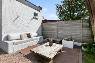 Sommige woningen hebben een sfeer die moeilijk te creëren valt. Deze charmante halfopen woning werd doorheen de jaren <strong>met zorg gerenoveerd, met respect voor haar authentieke karakter én aandacht voor hedendaags wooncomfort</strong>. Hoge plafonds, sierlijke moluren en originele vloeren worden afgewisseld met meer eigentijdse elementen en zorgen samen voor een warme, tijdloze uitstraling.<br /><br />Ook de ligging is bijzonder sterk: de Veldlei bevindt zich <strong>pal in het centrum van ’s-Gravenwezel</strong>, waardoor winkels, horeca en dagelijkse voorzieningen eenvoudig te voet bereikbaar zijn. Ook openbaar vervoer bevindt zich vlakbij en de wekelijkse markt ligt op korte wandelafstand. Zo geniet u van het gemak van centraal wonen, terwijl u achteraan over een eigen zonnige tuin beschikt.<br /><br /><strong>Indeling</strong><br />Vooraan is een parkeerplaats voorzien. De woning kan zowel via de inkomhal als via de zijkant worden betreden, waarbij die laatste toegang rechtstreeks naar de keuken leidt, bijzonder praktisch in het dagelijkse gebruik.<br /><br />Via de voordeur komt het karakter van de woning meteen tot zijn recht: <strong>hoge plafonds, authentieke vloeren en fraaie moluren</strong> zetten onmiddellijk de toon. Vanuit de inkomhal bereikt u zowel de woonkamer als de keuken.<br /><br />De woonkamer sluit aan op een veelzijdige ruimte die naar wens kan worden ingericht als eetkamer, bureau of speelkamer. Verder bevindt zich een afzonderlijke polyvalente bureau- of hobbyruimte, die bovendien rechtstreeks van buitenaf toegankelijk is en daardoor verschillende gebruiksmogelijkheden biedt.<br />De keuken met gezellige eet- of ontbijthoek werd afgewerkt met een strakke betonnen gietvloer en vormt een mooi hedendaags contrast met de authentieke elementen elders in de woning. Vanuit de keuken bereikt u rechtstreeks het terras en de tuin.<br />Op het gelijkvloers bevindt zich verder een badkamer met douche, ligbad en lavabomeubel.<br /><br /><strong>Eerste verdieping</strong><br />Op de eerste verdieping bevinden zich <strong>drie slaapkamers.</strong><br />Tot slot beschikt de woning over een praktische kelder.<br /><br /><strong>Tuin</strong><br />Achteraan wacht een <strong>onderhoudsvriendelijke zuidgerichte tuin</strong> met een gezellig terras. Dankzij de gunstige oriëntatie vormt dit een aangename, zonnige buitenplek die mooi aansluit op het karakter en de schaal van de woning.<br /><br /><strong>Bijzonderheden</strong><br />Het <strong>recent vernieuwde en geïsoleerde dak</strong>, de zuidgerichte tuin en vooral de combinatie van authentieke elementen met zorgvuldig gekozen hedendaagse ingrepen maken deze woning tot een bijzonder charmant geheel op een toplocatie in ’s-Gravenwezel.