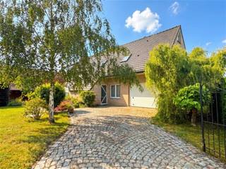 Exclusieve gezinswoning met 3 slaapkamers, bureau, grote schuur en bloemenrijke tuin in Stekene.Op een aantrekkelijke locatie, met een kleuter- en basisschool, bakker, slager en apotheek op wandelafstand, bevindt zich deze instapklare en lichtrijke woning. Dankzij de vlotte verbinding met de E34 en de nabijheid van Hulst (NL) geniet u hier van de ideale combinatie van rust, bereikbaarheid en dagelijkse voorzieningen.De inkomhal biedt enerzijds toegang tot een afzonderlijke bureauruimte en een gastentoilet, en anderzijds tot het woongedeelte. Ideaal voor wie graag klanten thuis ontvangt en werk en privé gescheiden wil houden, of voor wie in alle rust van thuis uit wil werken. Aansluitend bevindt zich de bijzonder lichtrijke eetkamer met zicht op de tuin, evenals de gezellige leefruimte met parketvloer. Ook de ruime keuken beschikt over een aangename eethoek.De woning telt drie volwaardige slaapkamers en een uitzonderlijk ruime badkamer, uitgerust met een ligbad, douche, dubbele lavabo en toilet. Daarnaast is er op het gelijkvloers een praktische wasplaats voorzien, met voldoende ruimte voor meerdere toestellen en al uw poets- en strijkmateriaal. Extra bergruimte nodig? Die vindt u op de ruime zolder.Buiten geniet u van een fraai aangelegde, bloemenrijke tuin met een sfeervolle waterpartij en een overdekt terras waar het heerlijk vertoeven is. Een absolute troef is de ruime schuur van maar liefst 105 m², die tal van mogelijkheden biedt voor zelfstandigen, hobbyisten of extra opslagruimte.Verder beschikt de woning over twee garages, bijkomende parkeerplaatsen op eigen terrein en diverse extra's, zoals rolluiken, een regenwaterput, een omheinde tuin en ook de wachtbuizen voor toekomstige technieken liggen klaar.Hier geniet u van comfortabel wonen met tal van mogelijkheden.Deze woning wil gezien worden. Maak een afspraak via 03 779 69 29 of contact@eberhardvastgoed.be