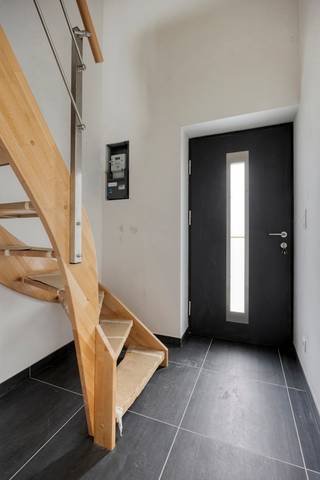 <p>Bij het betreden van de woning komt u binnen in de inkomhal, waar zich de trap naar de eerste verdieping bevindt, evenals een afzonderlijk gastentoilet. Vanuit de inkomhal bereikt u de zeer ruime leefruimte via een zwarte metalen deur met glaspartijen. Achteraan zijn de aansluitingen voorzien om zelf een keuken te plaatsen, de keuken dient nog door de koper zelf te worden aangekocht en geïnstalleerd. Boven de keuken zorgt een glazen lichtstraat voor een aangename en overvloedige lichtinval.</p>
<p>Verder is er een technische ruimte die tevens kan dienen als berging. Hier bevinden zich de aansluitingen voor de vloerverwarming, die zowel kan verwarmen als koelen (warmtepomp), de warmtepompboiler en de pomp van de regenwaterput.</p>
<p>Op de eerste verdieping zijn er twee slaapkamers en een badkamer. De badkamer is uitgerust met een inloopdouche, een toilet en de nodige voorzieningen voor een badkamermeubel. Daarnaast is er ook een beperkte zolderberging aanwezig, bereikbaar via een uitschuifbare trap.</p>
<p>Achteraan de woning bevindt zich een gezellig tuintje met een verhard terras. Aansluitend is er de mogelijkheid om een wagen te parkeren, al de aansluitingen voor een elektrische laadpaal zijn voorzien. In de kelder is bovendien een praktische kelderberging aanwezig.</p>
<p>Troeven van de woning:<br />✅ Extreem gunstig EPC met A+ label.<br />✅ Voldoende zonnepanelen.<br />✅ Driedubbele beglazing.<br />✅ Regenwaterput van 7.500 liter, aangesloten op toiletten en buitenkraan.<br />✅ Alle keuringen zijn conform.<br />✅ Keuken aan 6% btw.</p>
<p>En het grootste voordeel van allemaal: deze woning wordt te koop aangeboden onder registratierechten, niet onder btw!</p>
<p>Aarzel niet en contacteer ons vandaag nog voor een bezichtiging op het nummer 0499/30.87.87 of via info@immo-bosmans.be</p>