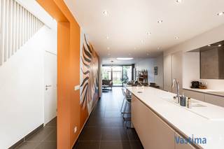 Ben je op zoek naar een woning waar je zó kan intrekken? Dan is deze prachtig gerenoveerde én energiezuinige woonst precies wat je zoekt. Alles is tot in de puntjes vernieuwd en helemaal klaar om nieuwe bewoners te verwelkomen die comfort, stijl en zorgeloos wonen belangrijk vinden.<br /><br />EPC B - 150 kwh - geen renovatieplicht / Asbestveilig / Lucht-luchtwarmtepomp / CV op aardgas / Dubbel glas / Elektriciteit conform / Regenwaterput - 5.000 L / Parkeerplaats voor de woning op openbaar domein … piekfijn onderhouden!<br /><br />Bij binnenkomst word je ontvangen in een ruime inkomhal met handige inbouwkasten voor jassen en schoenen, een aparte berging én gastentoilet. Je wandelt door naar de grote open leefruimte waar keuken, eetkamer en zithoek naadloos samenkomen. Dankzij de lichtkoepel en het brede schuifraam geniet je hier de hele dag van natuurlijk licht en zicht op de tuin.<br /><br />De volledig geïnstalleerde keuken is een echte eyecatcher: uitgerust met inductie, microgolfoven, oven, vaatwasmachine en een riant keukeneiland in natuursteen. Overal zijn voldoende stopcontacten voorzien en inbouwspots zorgen voor een moderne afwerking.<br /><br />Op de eerste verdieping bevindt zich een eerste slaapkamer, ook ideaal als bureau voor thuiswerk. De ruime badkamer is uitgerust met dubbele lavabo, ligbad én douche. Een praktische was- en bergruimte en een tweede toilet vervolledigen deze verdieping.<br /><br />Op de afgewerkte zolderverdieping, bereikbaar via een vaste trap, bevindt zich de ruime tweede slaapkamer. Met slimme opbergoplossingen werd elke centimeter optimaal benut. Hier werd een lucht-luchtwarmtepomp geïnstalleerd voor extra comfort.<br /><br />Buiten ontdek je een gezellige, onderhoudsvriendelijke stadstuin met terras én graszone: de ideale plek om te ontspannen. Achteraan staat een praktisch tuinhuis om al je tuinmateriaal netjes op te bergen.<br /><br />Ben jij klaar om deze instapklare gezinswoning te ontdekken? Wacht niet langer en vraag vandaag nog jouw bezoek aan!