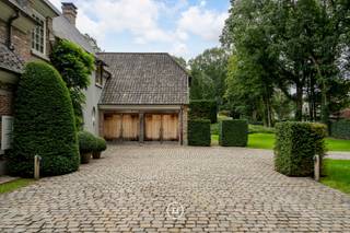 Deze landelijke villa, ontworpen door architect Bart François op een perfect georiënteerd perceel van 2730 m² heeft 4 slaapkamers, 2 badkamers en een grote garage voor 2 wagens.<br /><br />De woning is minutieus onderhouden, perfect instapklaar en biedt tal van mogelijkheden door de grote gezellige ruimtes, het prachtige uitzicht op de mooie tuin en de stijlvolle inrichting met warme materialen. Dit alles optimaal gelegen in een mooie dreef van Sint-Martens-Latem op 900 meter van de golf.<br /><br />Je komt de villa binnen via de inkomhal met trap, vestiaire en gastentoilet. De hal geeft toegang naar de gezellige zitplaats met open haard, die dan voorts een doorgang geeft naar de cosy tv-hoek. De eetruimte leidt naar een grote uiterst lichtrijke leefkeuken die voorzien is van alle toestellen. Al deze ruimtes staan mooi in contact met de tuin. In aansluiting met de keuken vind je een bijkeuken met wasplaats/berging en een ruime koelcel. Kers op de taart is de grote ingerichte en gekoelde wijnkelder op -1. Op het gelijkvloers voorts nog een gezellige en lichtrijke bureau en een inpandige garage voor 2 wagens met aansluitend berging en technische ruimte.<br /><br />Boven leidt de nachthal enerzijds naar het mastergedeelte met slaapkamer, grote dressing en badkamer (dubbele lavabo, bad, douche en toilet). Voorts op de verdieping het kinder- of gastengedeelte met 3 slaapkamers (waarvan één met grote dressing), apart toilet en badkamer met ligbad, hammam en wastafel. <br /><br />De tweede verdieping kan perfect ingericht worden als een verblijf voor de au-pair of kan omgevormd worden naar 2 extra slaapkamers.