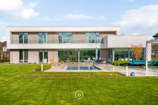 In een rustige en groene omgeving in Brakel bevindt zich deze moderne villa waar comfort, rust en hedendaagse luxe samenkomen. Een woning waar binnen en buiten naadloos in elkaar overvloeien en waar elke dag aanvoelt als wonen in een privé resort.<br /><br />De woning verwelkomt u via een ruime inkomhal met vestiaire en gastentoilet. De leefruimtes zijn bijzonder lichtrijk en worden gekenmerkt door grote raampartijen die zorgen voor een constante connectie met de tuin en het zwembad. De open indeling met zithoek, eetplaats en volledig uitgeruste keuken creëert een aangename en functionele leefomgeving.<br /><br />Op het gelijkvloers bevindt zich een slaapkamer met badkamer en directe toegang tot het terras, wat de woning extra flexibel maakt. De verdieping omvat een masterbedroom met dressing en ensuite badkamer met dubbele douche, wastafel en ligbad met verzicht. Aangevuld met een polyvalente ruimte die kan dienen als fitness, bureau of extra slaapkamer.<br /><br />De tuin vormt een verlengstuk van de woning en is volledig ingericht op beleving en ontspanning. Met een ingebouwd zwembad, poolhouse en meerdere terrassen biedt deze buitenruimte een uitzonderlijke woonkwaliteit. <br /><br />Voor wie maximaal wil genieten van ruimte, natuur en privacy, bestaat bovendien de mogelijkheid om de achterliggende boomgaard met fruitbomen mee aan te kopen, goed voor circa 0,5 hectare extra terrein. Deze uitbreiding versterkt het unieke landelijke karakter van de eigendom en biedt bijkomende mogelijkheden voor tuinbeleving, ontspanning of het creëren van een uitzonderlijk groen woonkader.<br /><br />Dankzij de combinatie van moderne technieken, energiezuinigheid en hoogwaardige afwerking is deze woning volledig instapklaar en klaar voor de toekomst.<br /><br />Een eigendom die zich onderscheidt door haar comfort, technologie en leefkwaliteit, in een rustige en aangename omgeving. Deze eigendom is beschikbaar vanaf 01/02/2027.