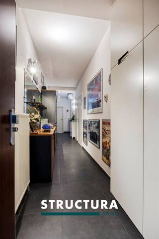 Dit ruime appartement van ca. 134 m² bevindt zich op de bovenste verdieping en combineert een kwalitatieve afwerking met bijzonder veel lichtinval dankzij de grote raampartijen. De ligging is praktisch, met winkels, openbaar vervoer, het UZ en de Ring in de nabije omgeving. Met onder meer 20 privatieve zonnepanelen, airconditioning, een conform gekeurde elektrische installatie en EPC-label B is het appartement bovendien goed uitgerust.IndelingDerde verdieping: inkomhal die overgaat in een ruime centrale hal, waar voldoende plaats is voor bijvoorbeeld een bureau of extra werkruimte met aansluitend de leefruimte met open en volledig ingerichte keuken, die luxueus en met kwalitatieve materialen werd afgewerkt. Verder zijn er twee ruime slaapkamers, een badkamer met dubbele lavabo en douche, met eveneens plaats voor een wasmachine en droogkast. Daarnaast beschikt het appartement over een apart toilet en een praktische berging.Ondergronds: Parkeerplaats met laadpaal verplicht bij aan te kopen aan € 30.000Karakteristieken- Ca. 134 m² bewoonbare oppervlakte- Grote raampartijen en veel natuurlijke lichtinval- 2 ruime slaapkamers- Luxueus uitgewerkte open keuken- Kwalitatieve afwerking- Airconditioning- 20 privatieve zonnepanelen- EPC B- Elektrische installatie conformEen ruim en verzorgd appartement met veel lichtinval, een sterke energieprestatie en een vlot bereikbare ligging. Interesse? Neem contact met ons op voor meer informatie of een bezoek ter plaatse via 02 460 80 46 of info@structura.be