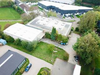 <p><strong>Showroom | Kantoren | Ateliers | Opslag</strong></p>
<p>Op een perceel van 3.927 m² biedt dit gebouw van ongeveer 1.770 m² nuttige oppervlakte een veelzijdige indeling die zeldzaam is op de markt, bewoond sinds de bouw door zijn enige en unieke eigenaar.</p>
<p><strong>Verdeling van de oppervlaktes</strong></p>
<p><strong>Niveau -1</strong><br />Een lichtrijke showroomruimte van 235 m², met een plafondhoogte van 9 m en talrijke lichtkoepels, aangevuld met een inkomhal van ±185 m² alsook sanitair, kleedkamers, traphal en stookplaats (±50 m²).</p>
<p><strong>Niveau 0</strong><br />Bijna 1.220 m², bestaande uit onthaal en kantoren (385 m²), een eerste magazijn van 445 m² onder ±6 m hoogte met sectionale poort, en een tweede magazijn afkomstig van de uitbreiding uit 2006 (390 m², ±5 m hoogte, eveneens met sectionale poort).</p>
<p><strong>Niveau +1</strong><br />315 m² kantoren, met een grondreserve die een toekomstige uitbreiding van ongeveer 200 m² mogelijk maakt.</p>
<p><strong>Technische troeven</strong><br />Het gebouw beschikt over fotovoltaïsche panelen op het dak, gasverwarming voor de magazijnen en de showroom, radiatoren op gasketel voor de kantoren, een gepolierde betonvloer, een gemengde structuur van hout/betonmetselwerk, houten raamkozijnen, een systeem van nachtelijke koeling in de showroom, 2 douches en een alarm.</p>
<p><strong>Toegang &amp; parking</strong><br />Ongeveer 20 parkeerplaatsen verdeeld over twee afzonderlijke toegangen (Avenue Newton en Tienne de la Petite Bilande).</p>
<p><strong>Voorwaarden</strong><br />Verkoop onder de vorm van een Share Deal (overdracht van aandelen van de vastgoedvennootschap, details op aanvraag). Onroerende voorheffing: 9.740 €</p>