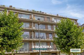 Laissez-vous surprendre par ce magnifique appartement rénové, situé au calme à proximité du centre de Zellik. Une combinaison idéale de confort, de style et d’accessibilité ! L’appartement dispose d’un spacieux et lumineux séjour avec accès à la terrasse. Dans le prolongement se trouve la cuisine moderne, aménagée avec goût et équipée d’appareils de qualité, ainsi qu’un débarras pratique. Le hall d’entrée central, doté d’armoires encastrées, sépare les espaces de vie et de nuit. L’appartement comprend également deux chambres avec des fenêtres orientées au nord, une belle salle de bains rénovée avec double lavabo et élégante douche à l’italienne, ainsi qu’un WC séparé. Sur le plan technique également, l’appartement a fait l’objet d’importantes améliorations : * Chaudière à condensation (2022). * Installation électrique conforme. * PEB B (144 kWh/m² par an). * Roofing renouvelé (2024). * Ascenseur renouvelé (2024). Un garage doit obligatoirement être acheté au prix de 25.000 € – une véritable plus-value à Zellik ! La provision mensuelle s’élève à environ 300 € et comprend la consommation privative de chauffage, d’eau chaude et d’eau froide, ainsi que les charges communes (ascenseur, syndic, entretien de l’immeuble, …). Un appartement prêt à emménager, bénéficiant d’un excellent emplacement, à proximité immédiate des commerces, des transports en commun et des autres commodités. Mesures administratives inscrites au Registre des mesures : non. Vous souhaitez davantage d’informations ou organiser une visite sur place ? Contactez STRUCTURA au 02 460 80 46 ou via info@structura.be.
